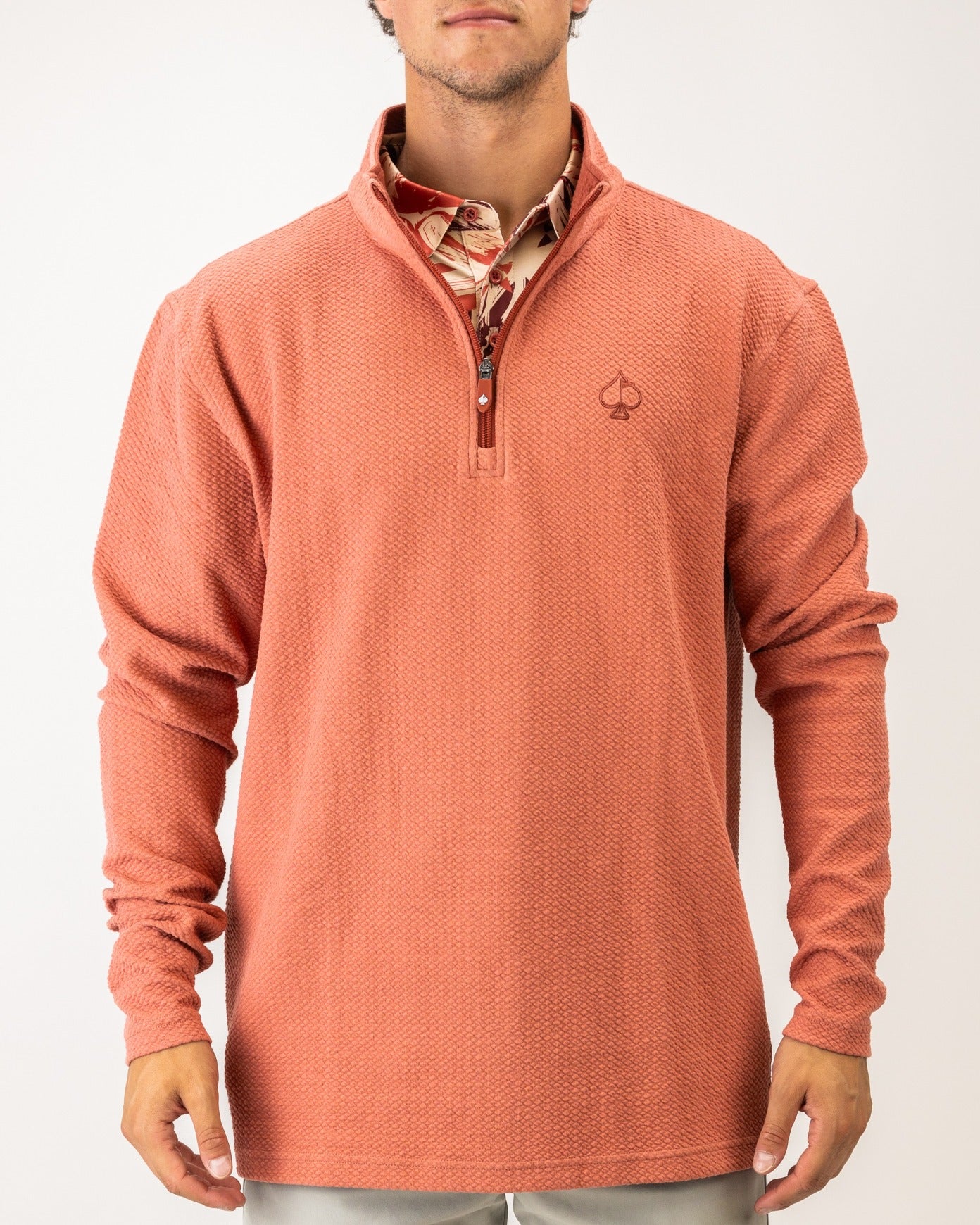 Terracotta waffle knit pullover with a quarter zip and logo, perfect for stylish comfort on the golf course.