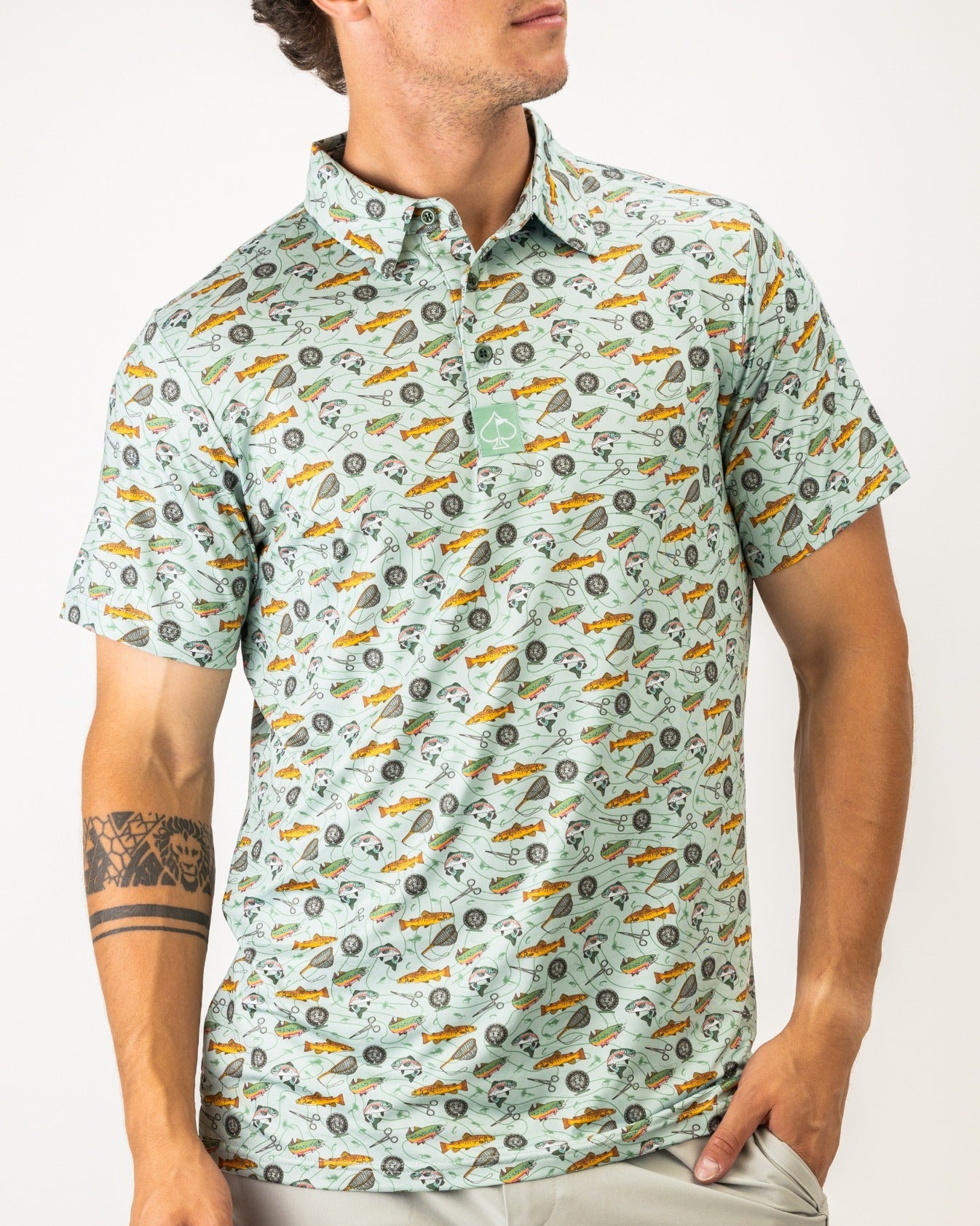 Men's short-sleeve golf shirt featuring a playful fish and fishing gear pattern, perfect for stylish golfers.