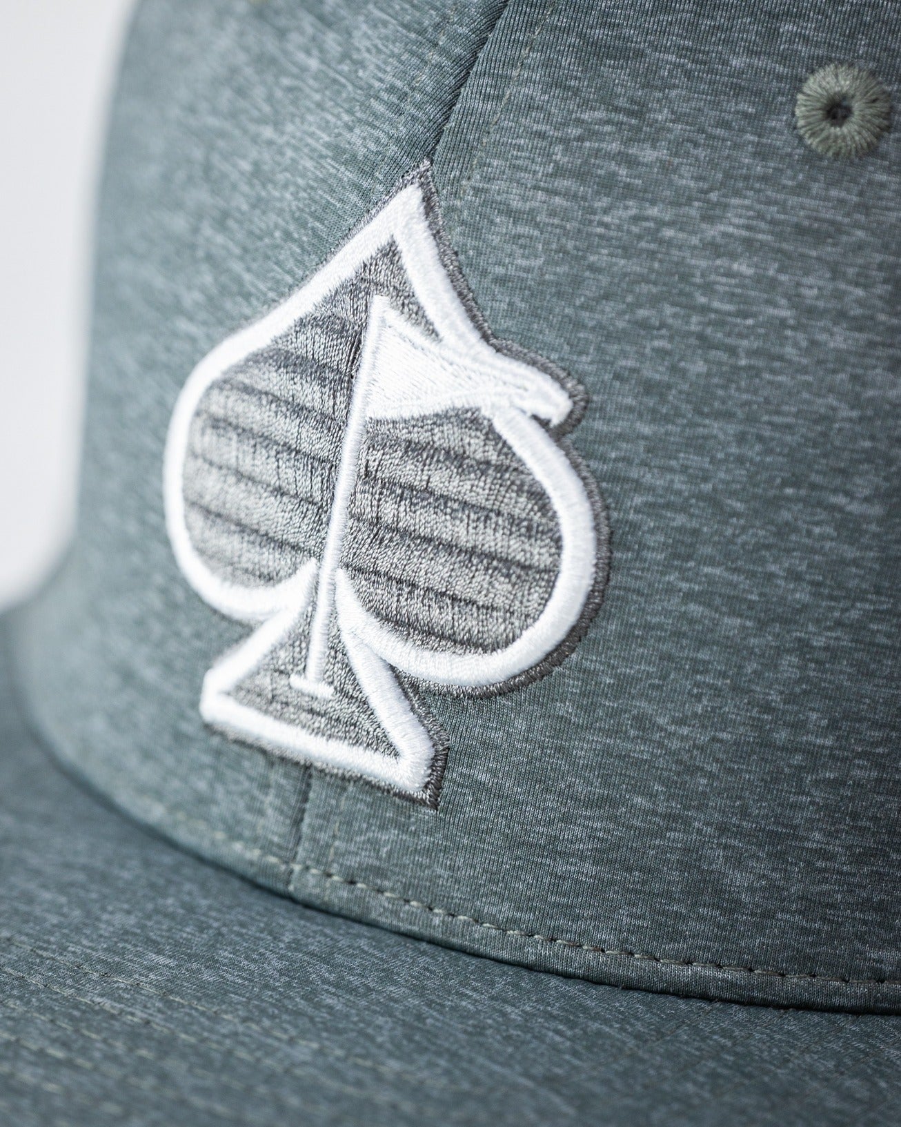 Ash-colored Performance Spade Hat featuring a prominent embroidered spade logo, perfect for stylish golfers.