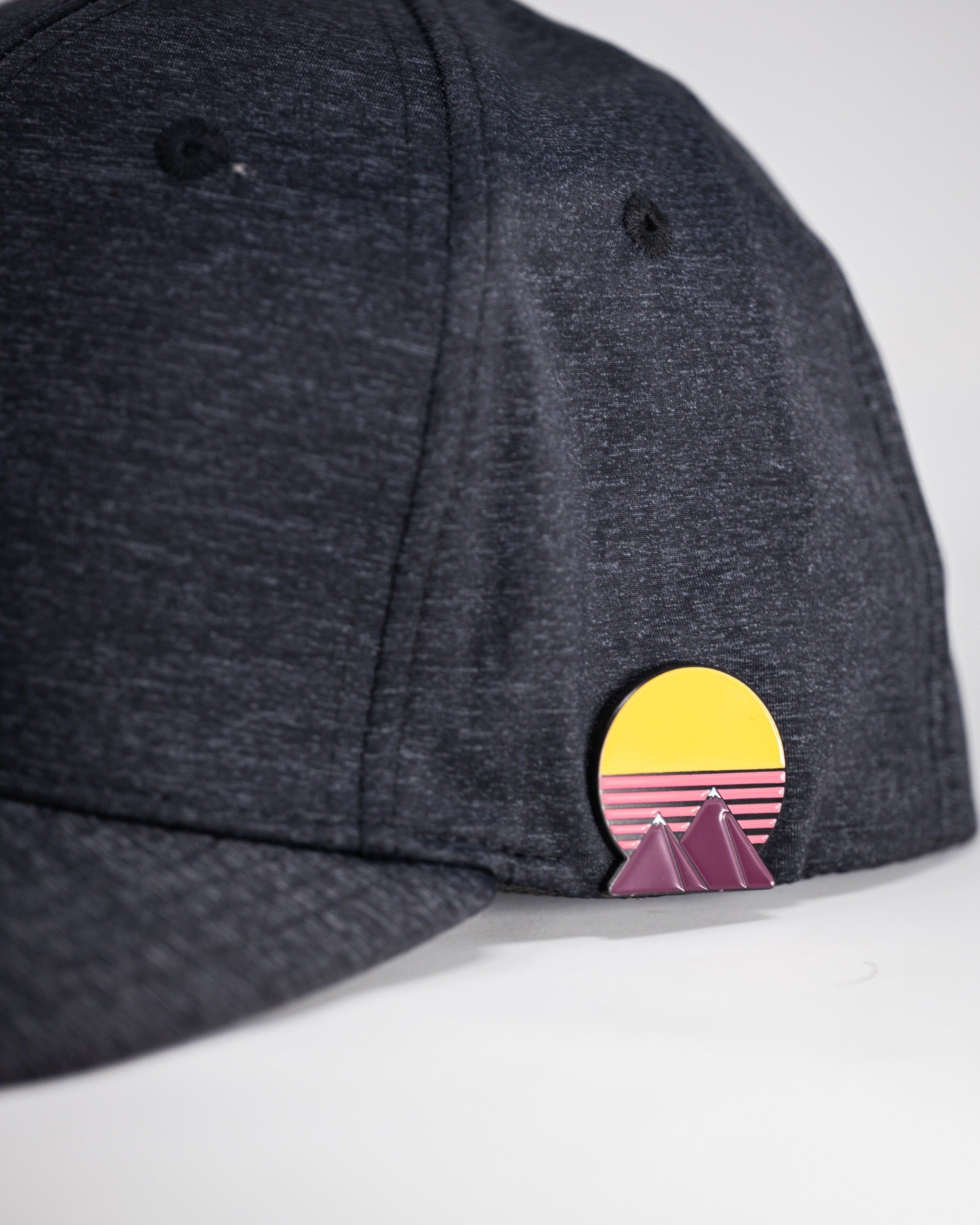 Charcoal performance spade hat featuring a colorful sunset and mountain design on the side for stylish golf wear.