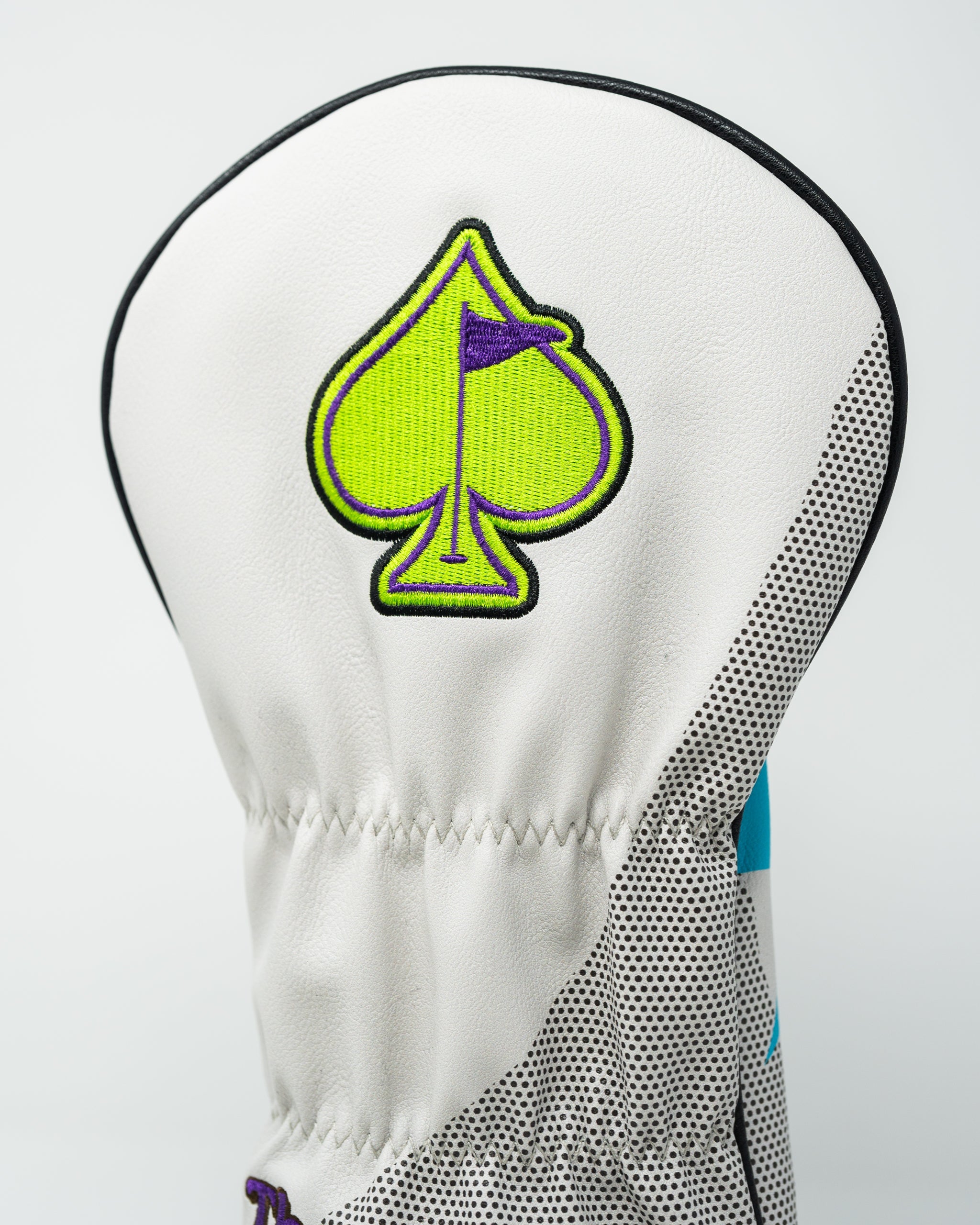 Stylish golf driver cover featuring a green spade emblem, designed for golfers seeking bold accessories on the course.