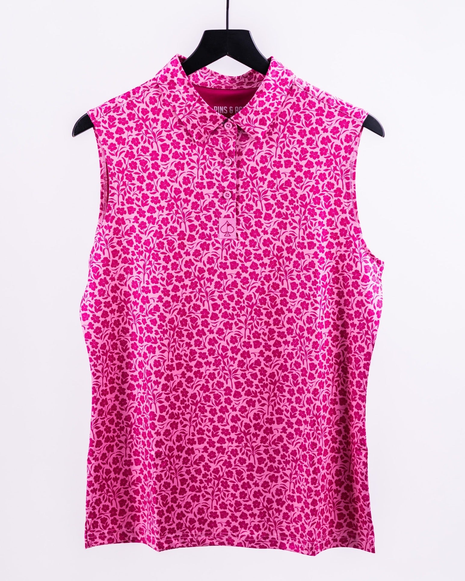 Bold pink sleeveless golf shirt with a floral pattern, collar, and button front for standout style on the course.