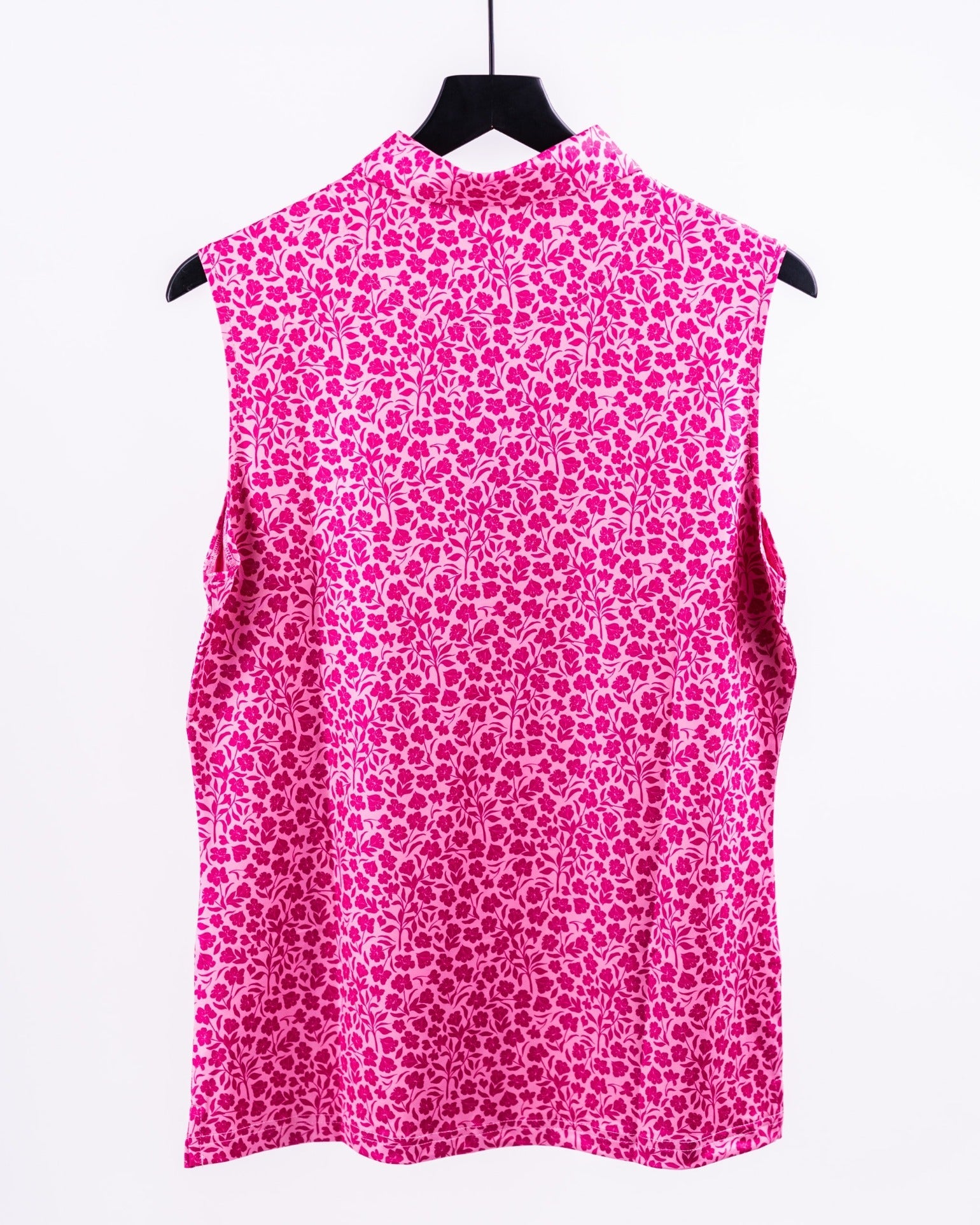 Pink sleeveless golf polo with a bold floral pattern, perfect for golfers who want to stand out on the course.