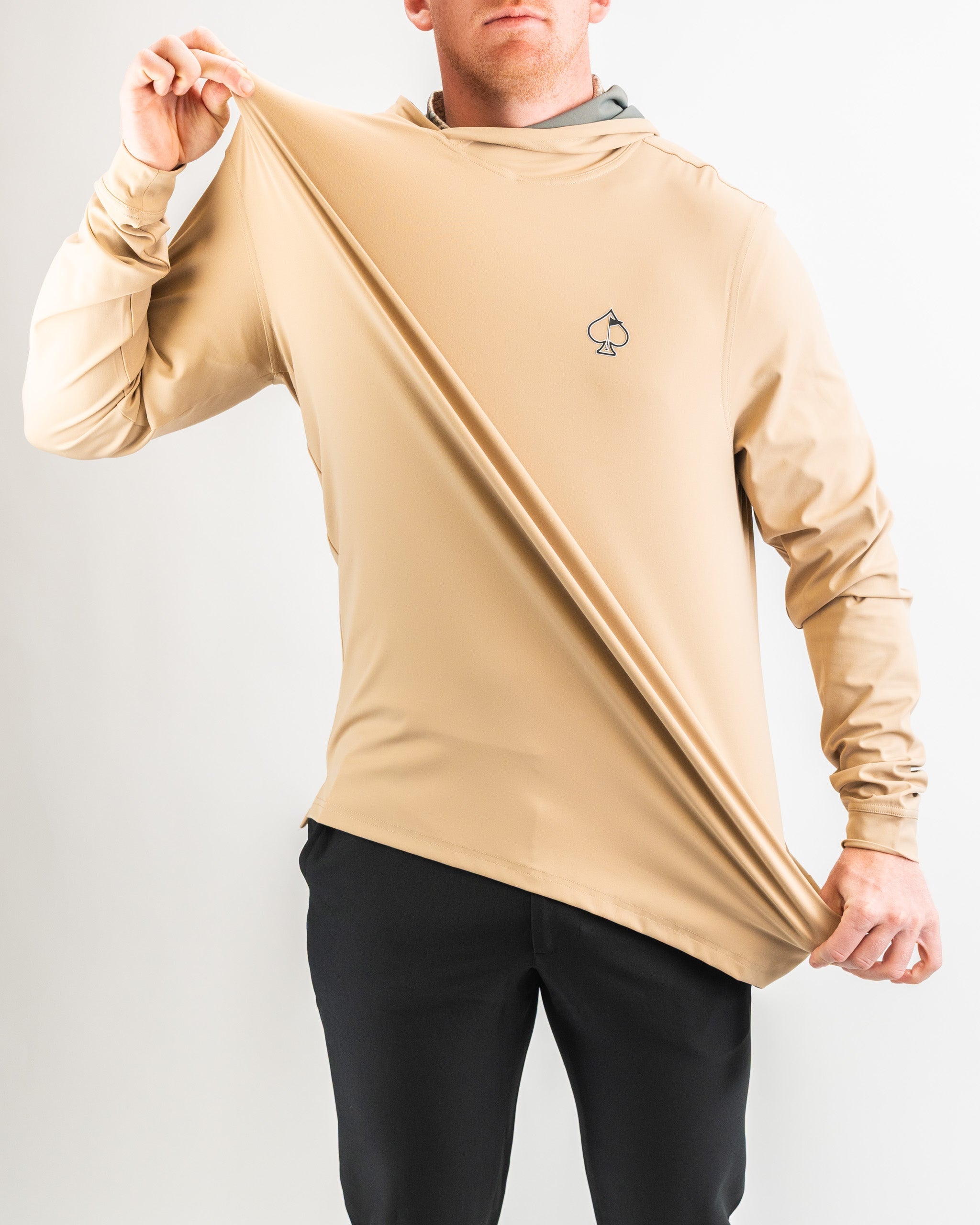 Performance golf hoodie in sand color, featuring a sleek design and logo, ideal for stylish comfort on the course.