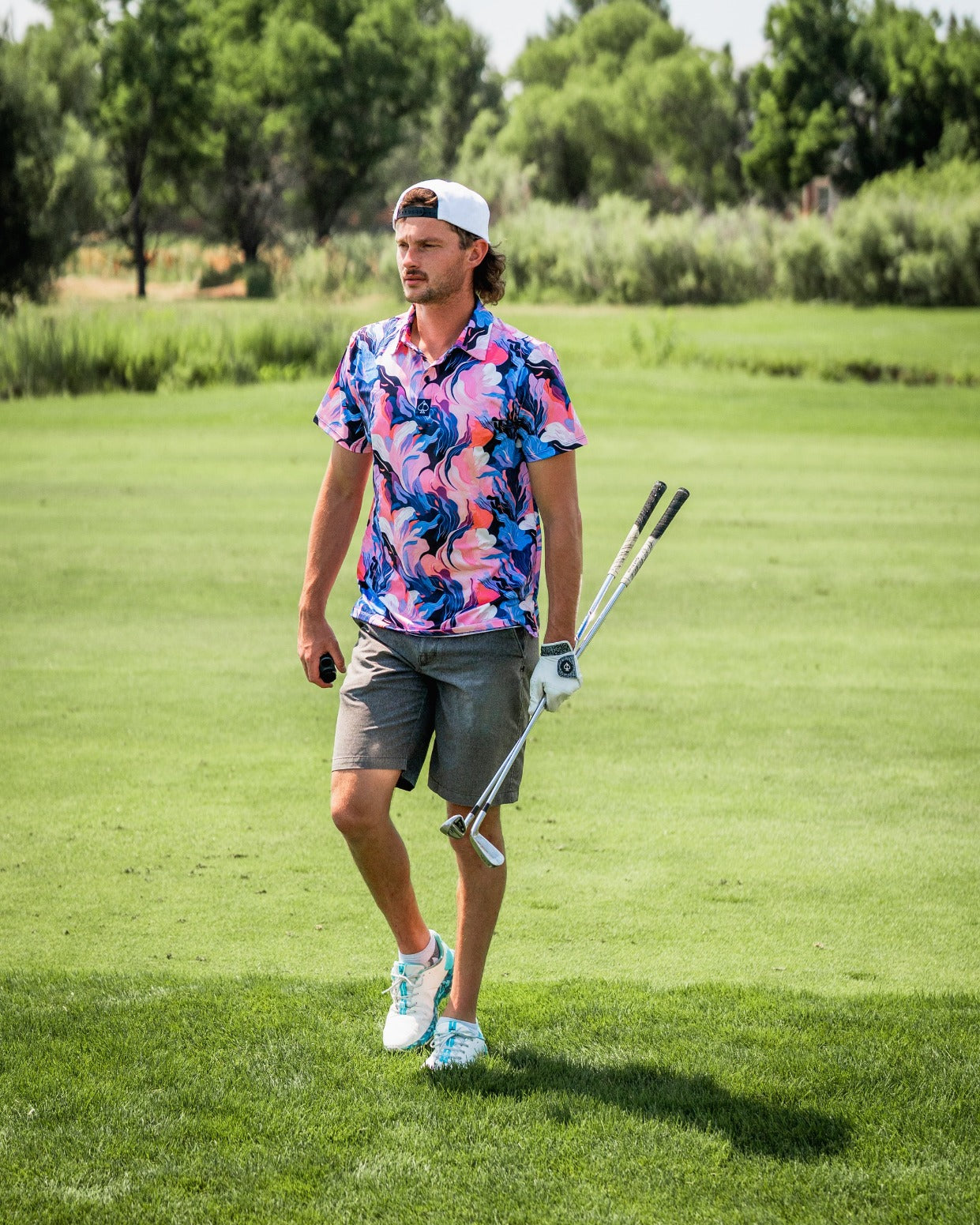 Bold Melting Floral golf shirt on a golfer walking on the course, showcasing vibrant colors and a stylish design.