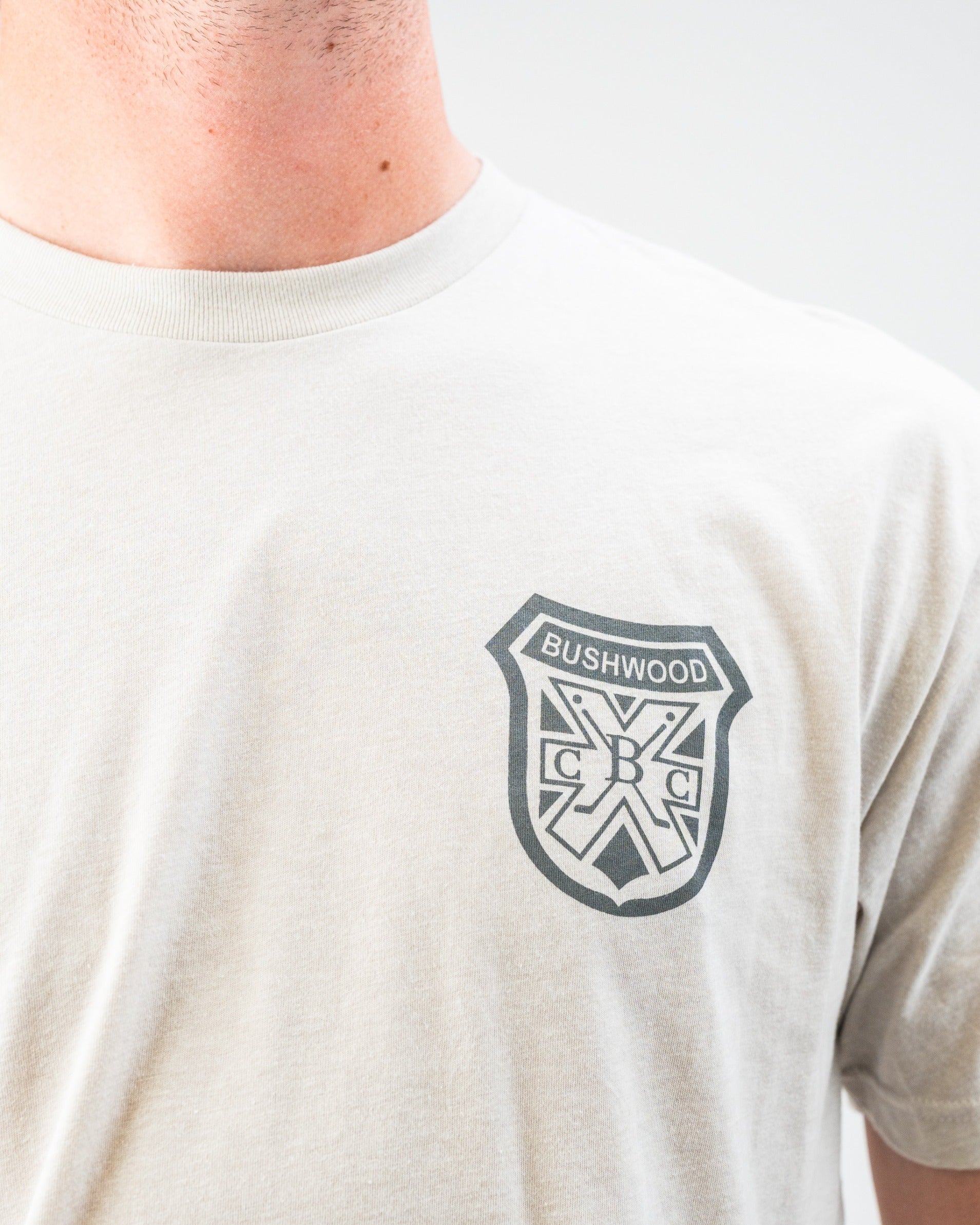 Light gray tee shirt featuring the Bushwood Crest logo on the left chest, perfect for stylish golf outings.