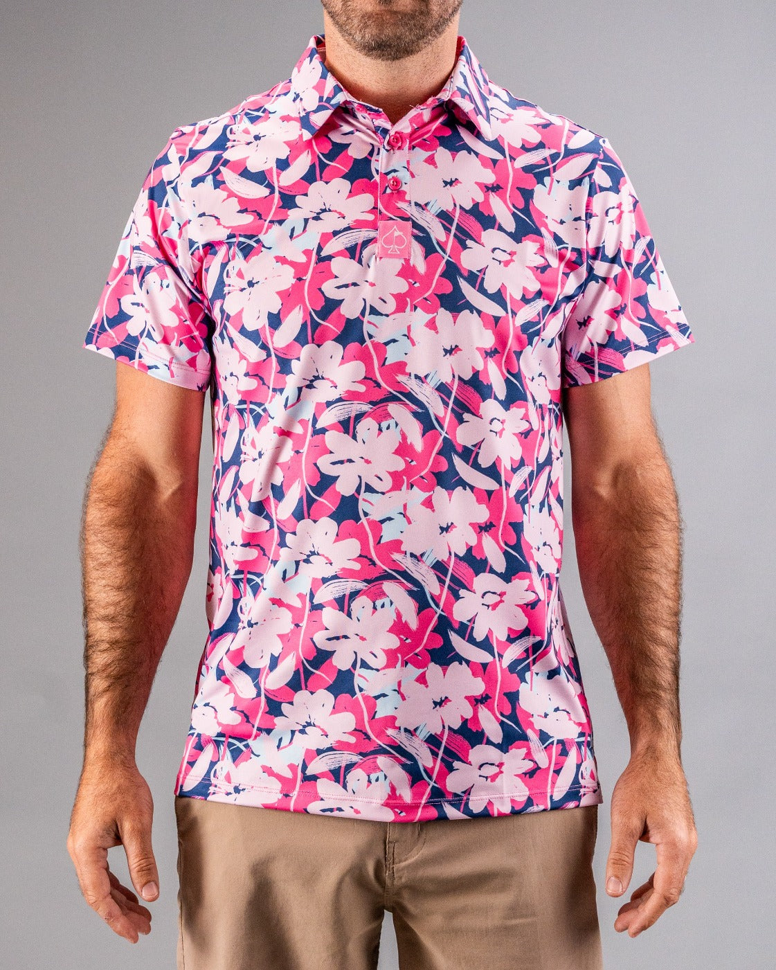 Bright pink, white, and navy floral golf shirt with a collar and short sleeves, perfect for bold, standout style on the co...