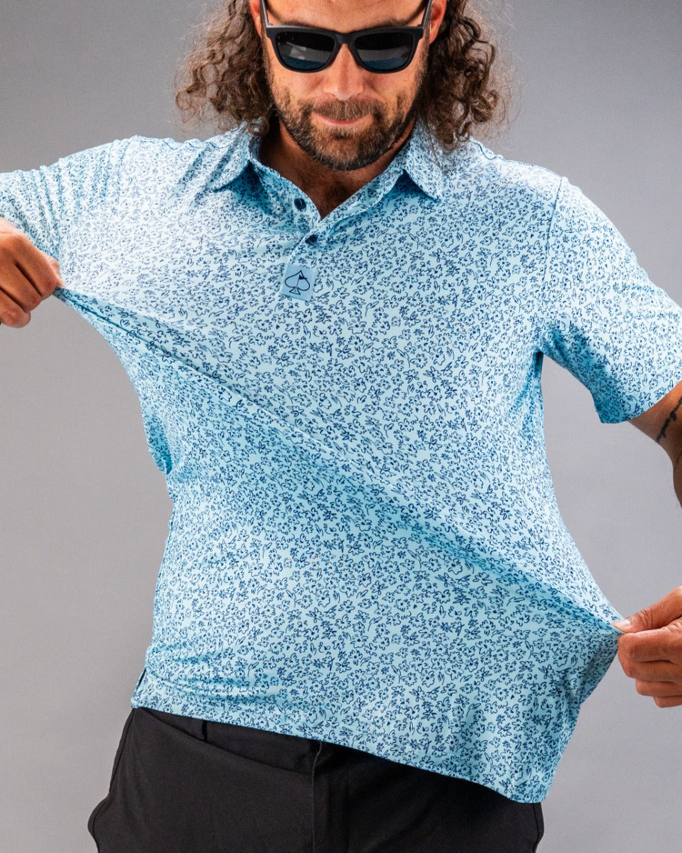 Man wearing a light blue golf shirt with a flower doodle pattern, showcasing its relaxed fit and style.