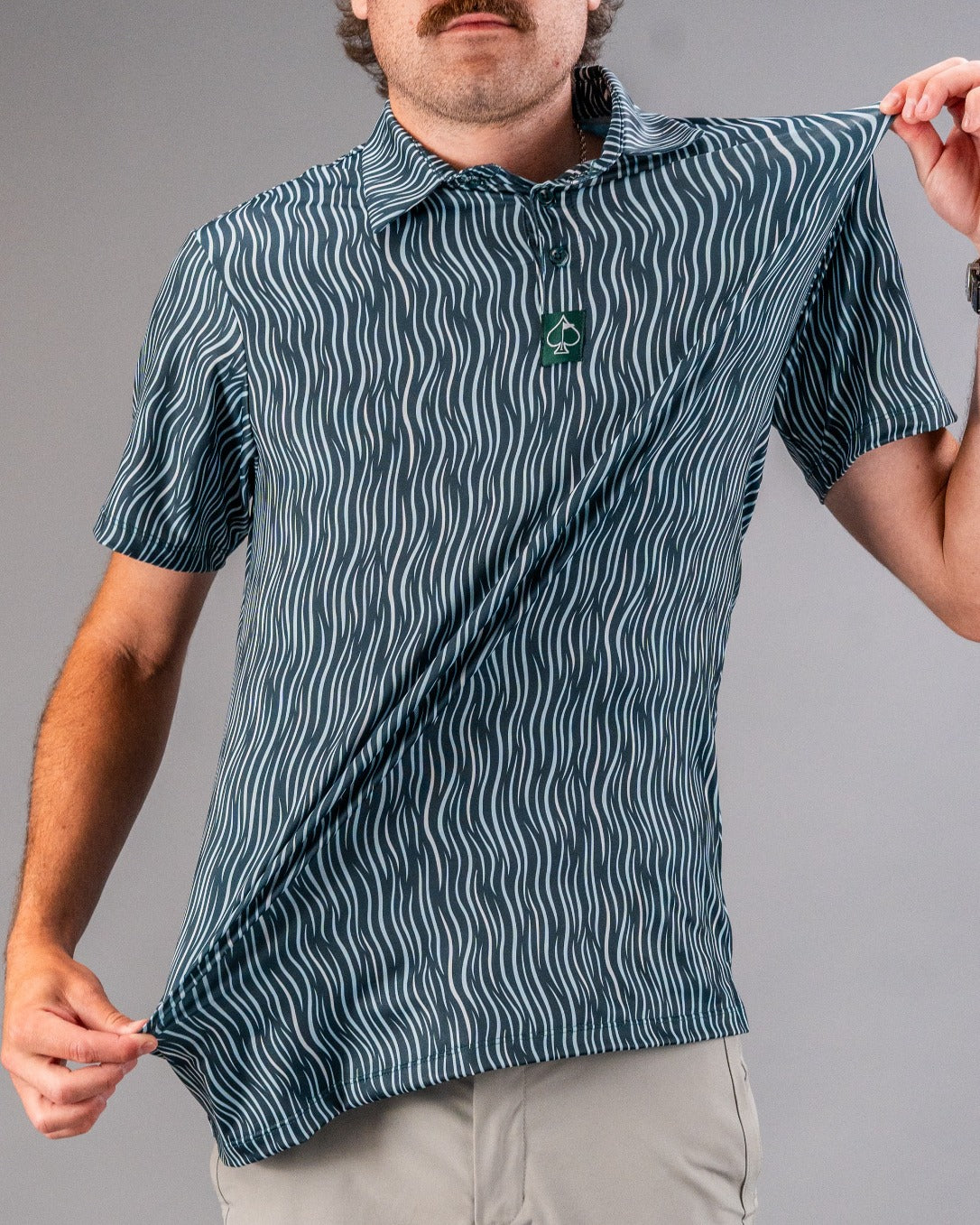 Men's blue and white patterned golf polo with zigzag design, short sleeves, and a collar, perfect for bold golf style.