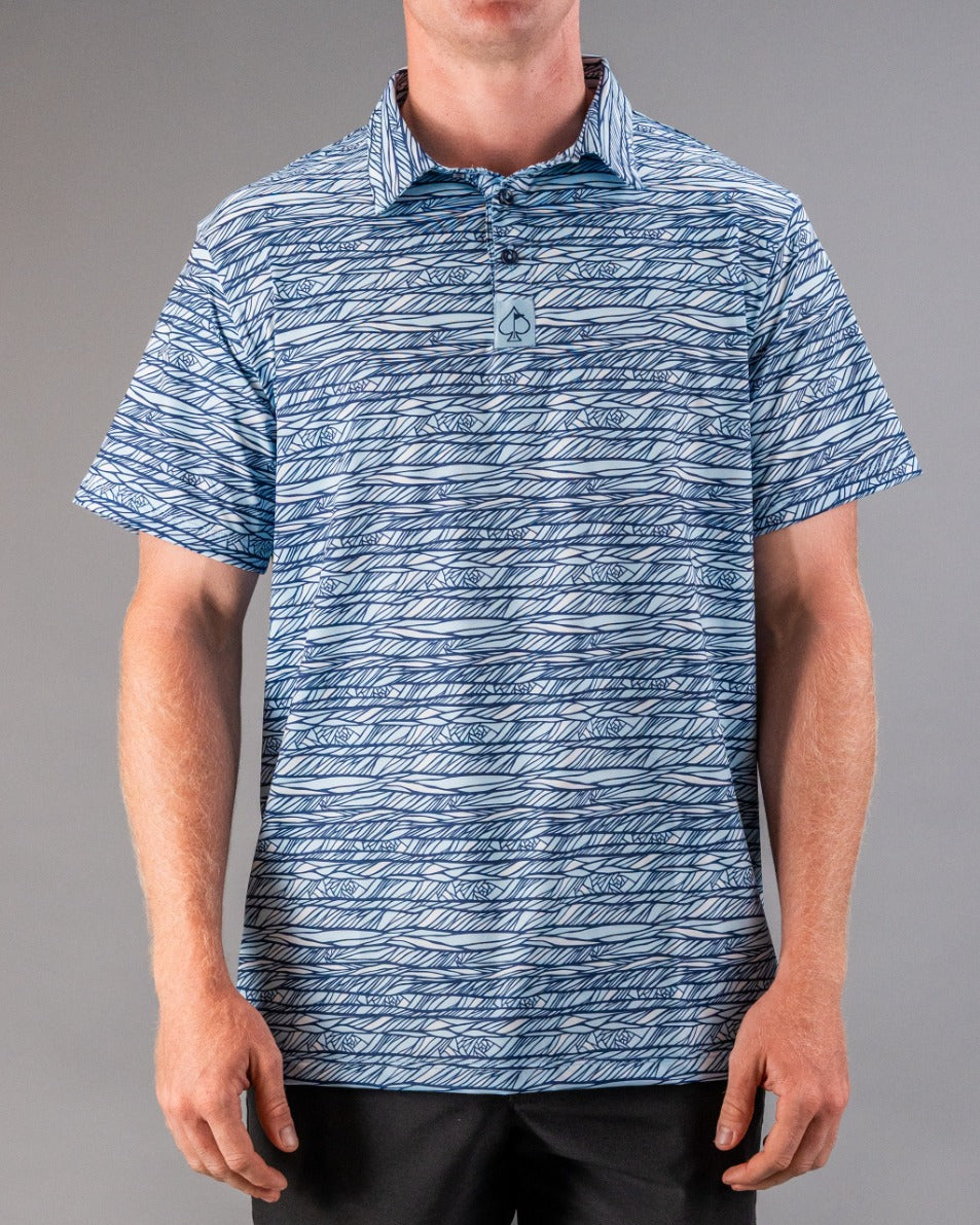 Men's blue and white patterned golf polo with a spade logo, featuring bold, intricate line designs for standout style on t...