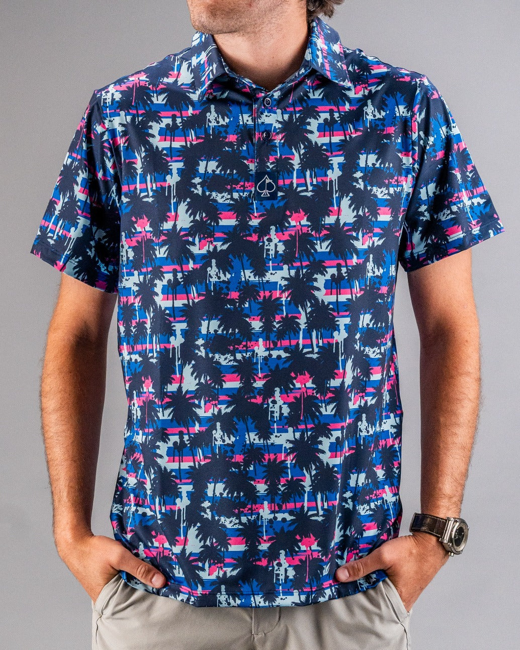 Colorful tropical print golf shirt with navy, pink, and light blue palm trees, perfect for bold golf style.