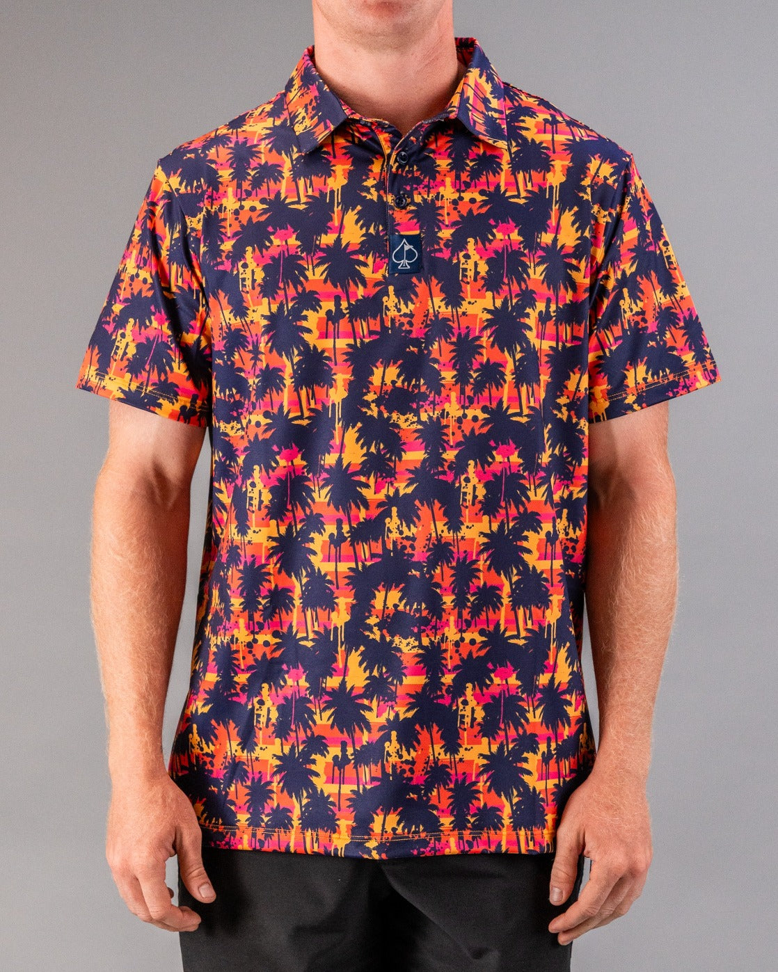 Bright tropical-themed golf polo with pink, orange, yellow, and navy palm trees, perfect for standing out on the course.