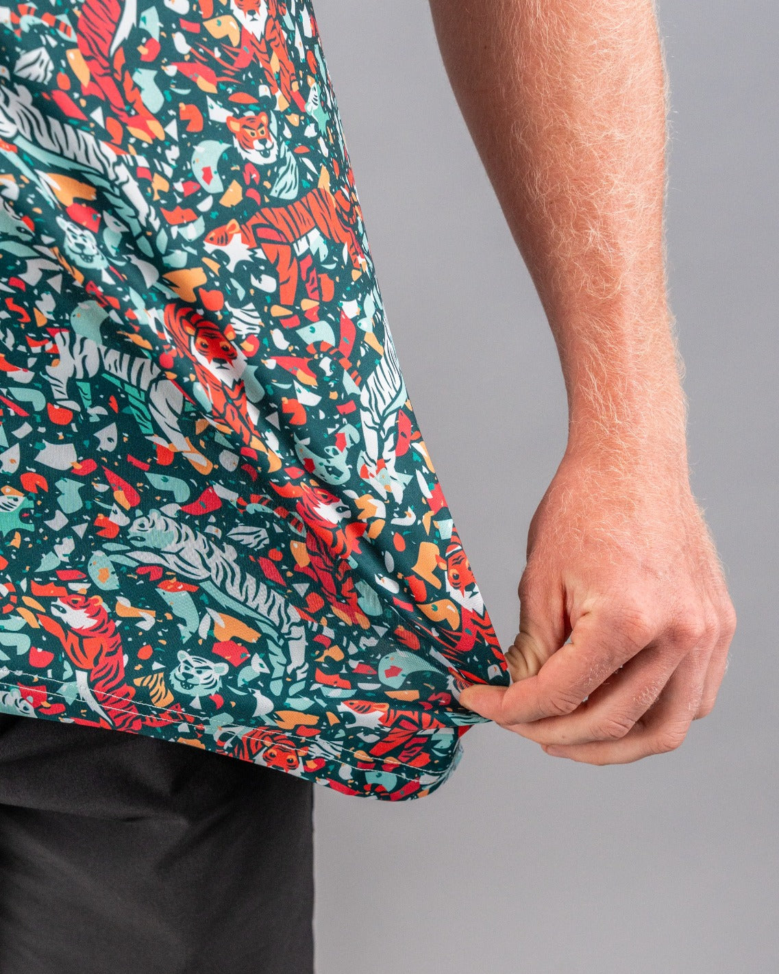 Bold golf shirt featuring a vibrant teal pattern with tigers and abstract shapes, perfect for standing out on the course.