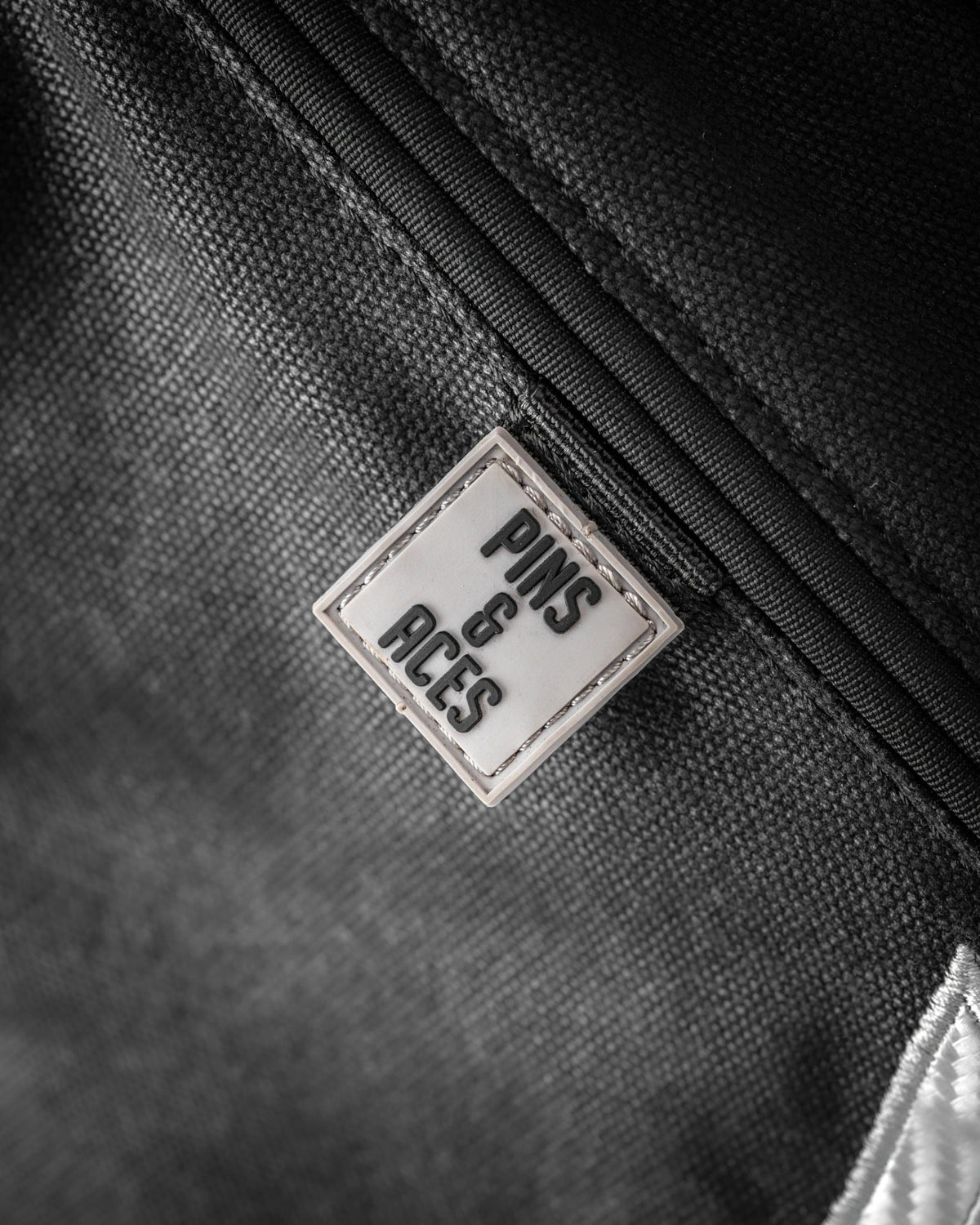 Stylish Sunday golf bag featuring a sleek design and the Pins and Aces logo, perfect for golfers on the go.