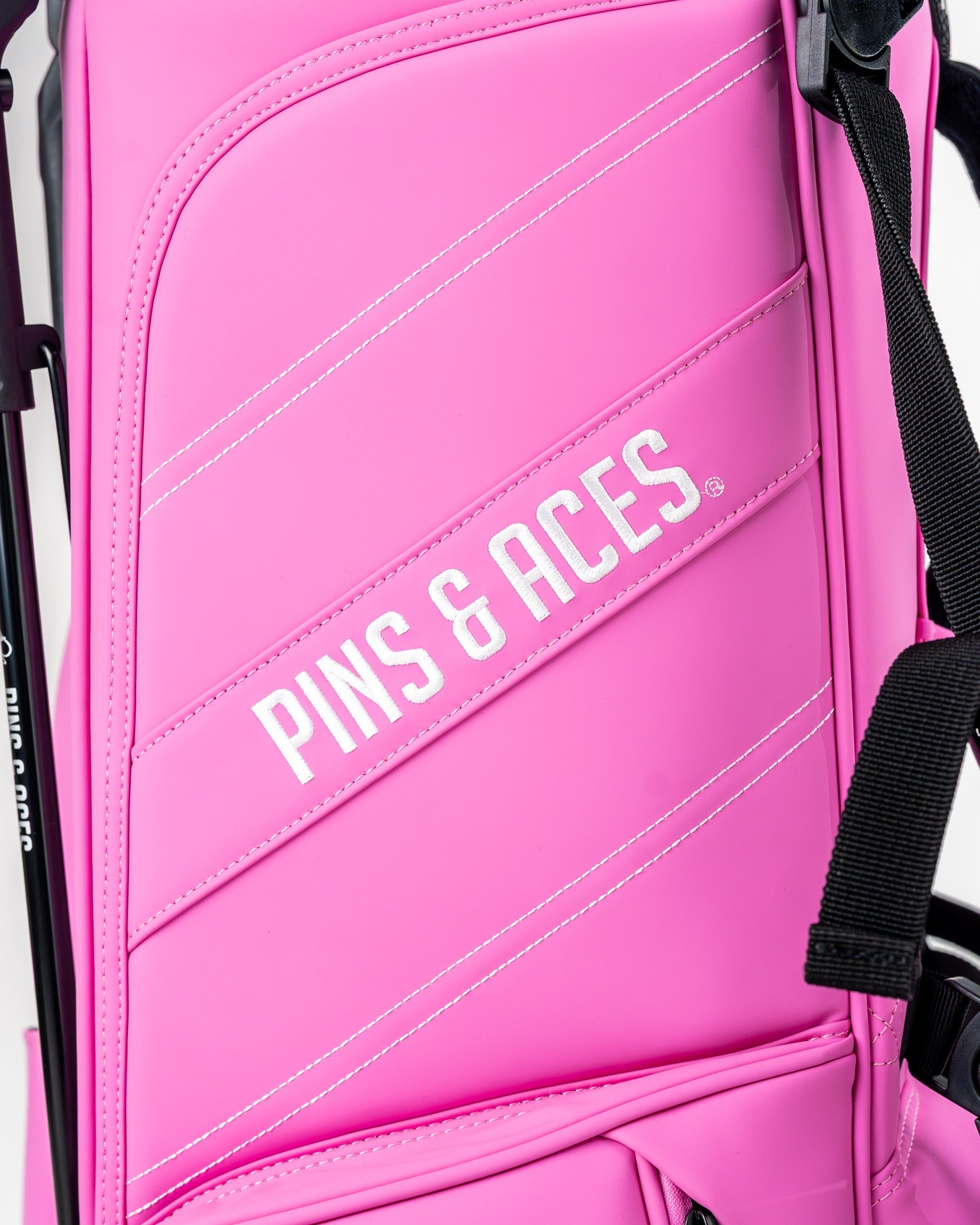 Bold pink golf bag featuring the Pins & Aces logo, designed for style and functionality on the golf course.