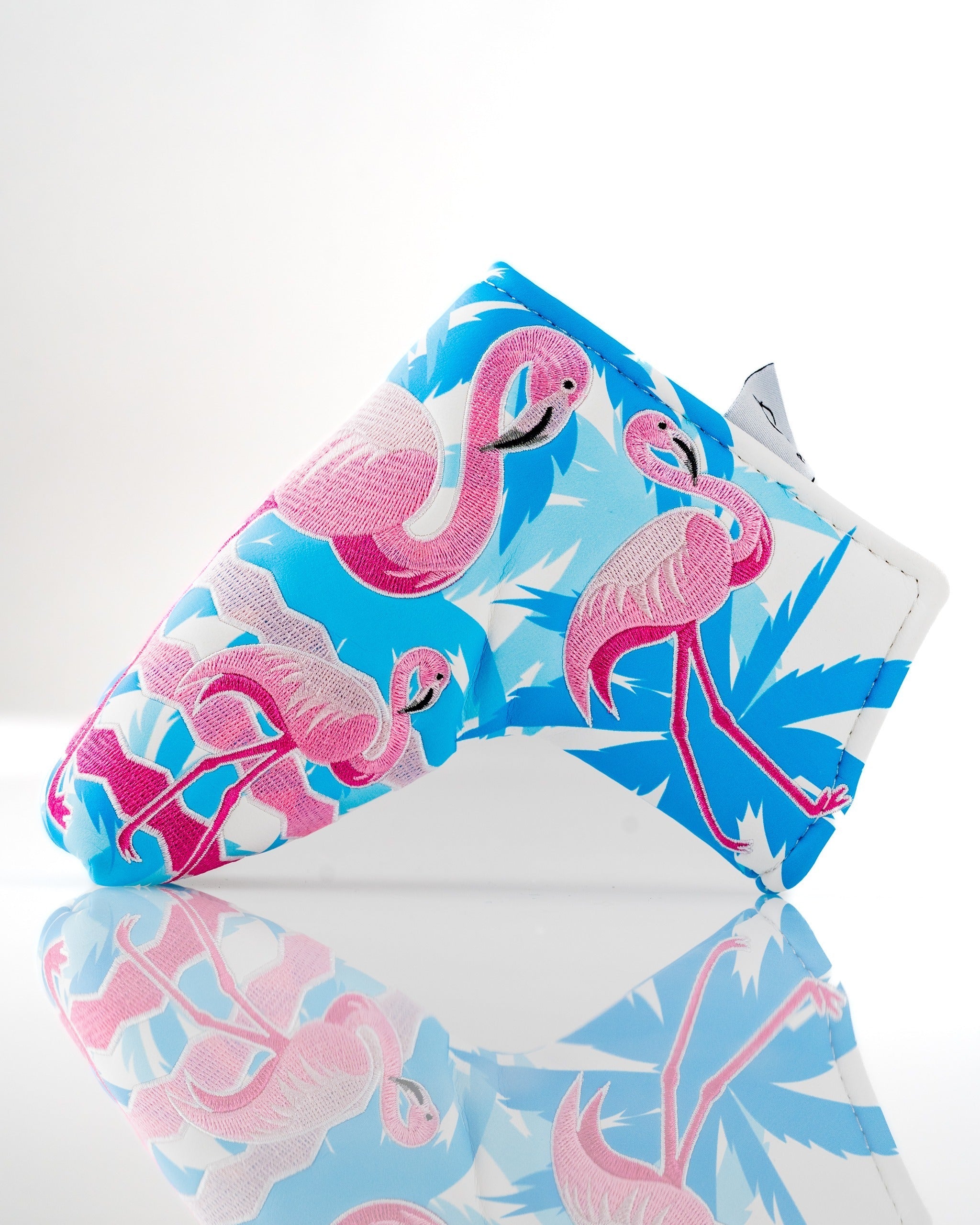 Bright flamingo-patterned blade putter cover featuring vibrant blue and pink colors, perfect for stylish golfers.