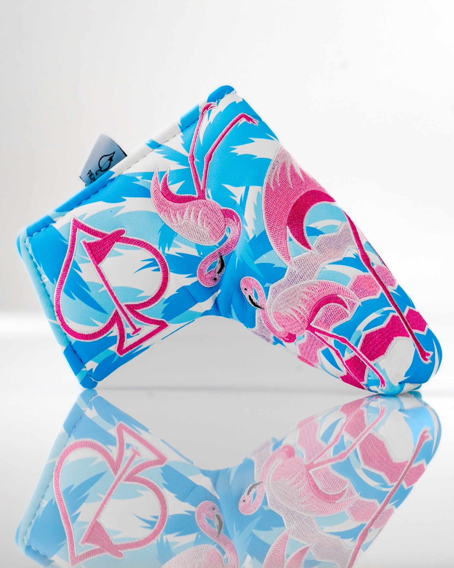 Bright blue blade putter cover featuring a vibrant flamingo pattern, perfect for golfers seeking a bold accessory.