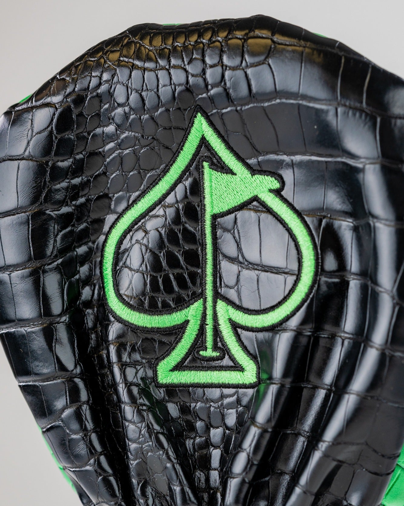 Bold T-Rex driver cover featuring a black crocodile texture and vibrant green spade logo, perfect for standout golf style.
