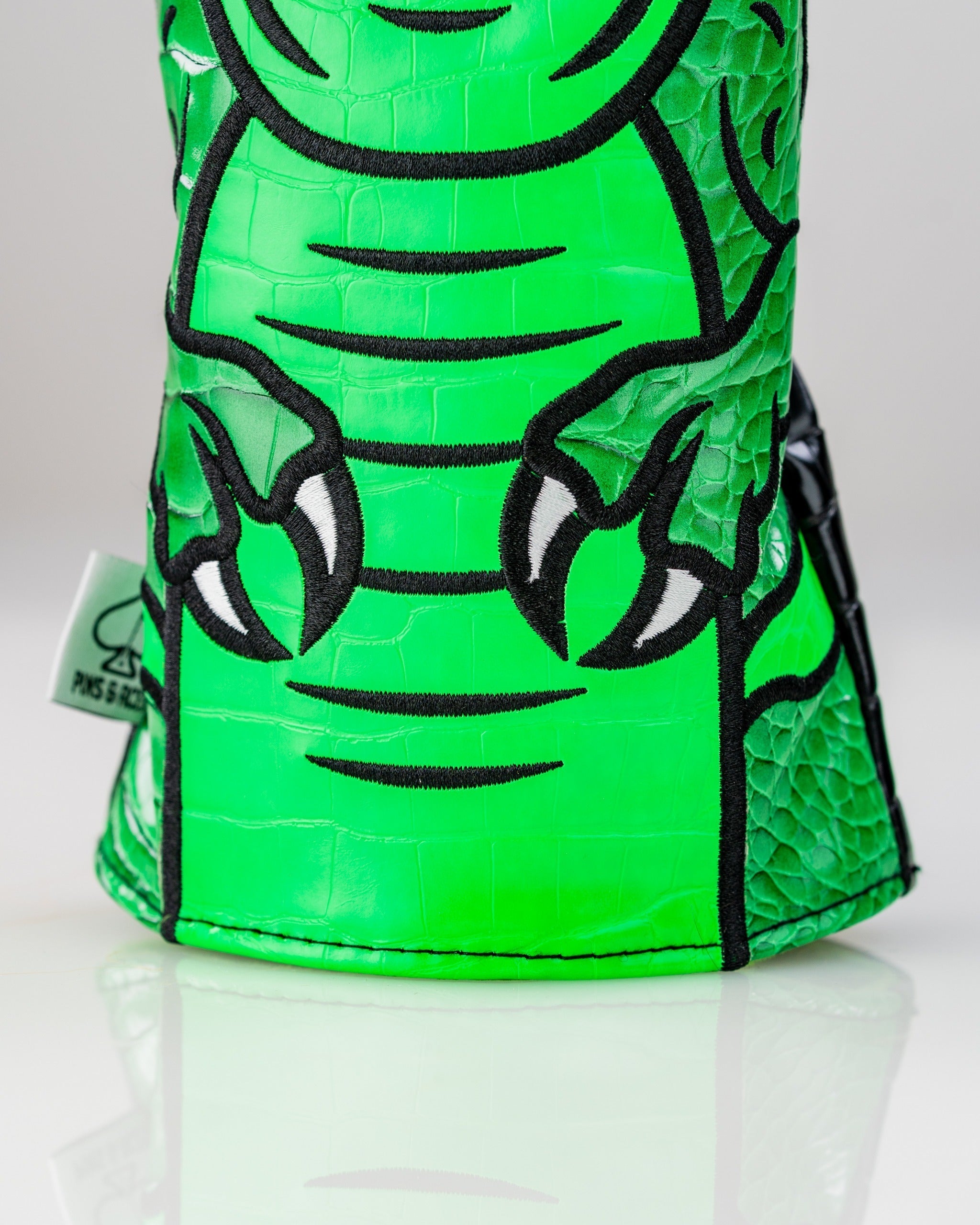 Bold green T-Rex driver cover featuring textured design and detailed claw graphics, perfect for standout golf style.