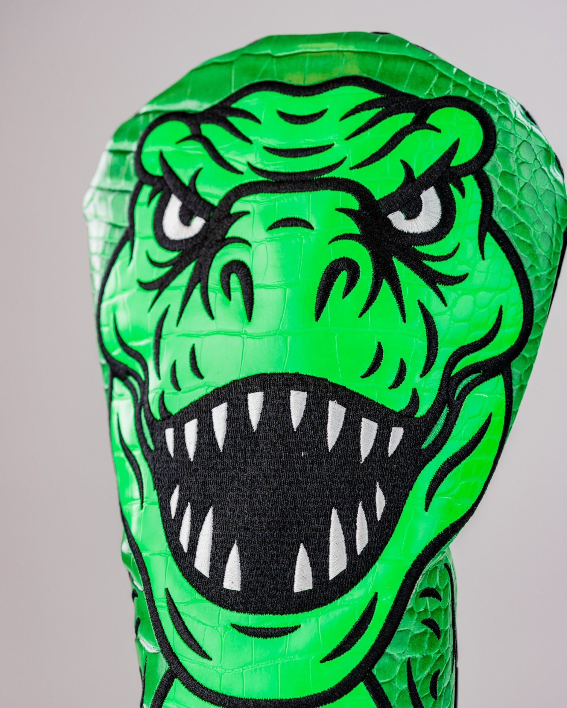 Bold green T-Rex driver cover featuring a fierce dinosaur design, perfect for golfers wanting to stand out on the course.