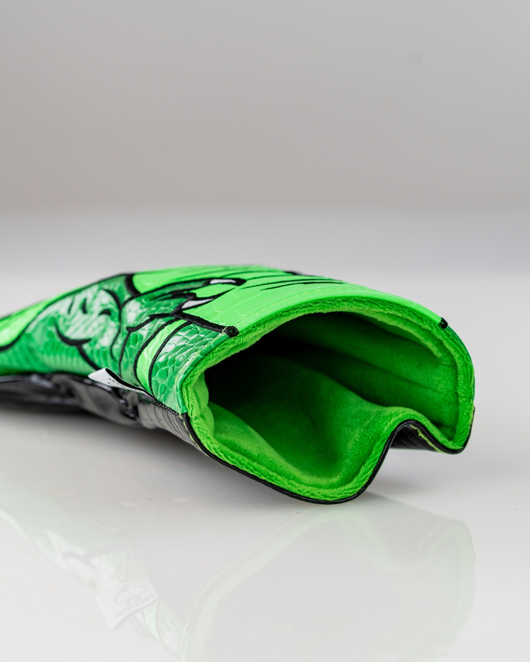 Bright green T-Rex driver cover featuring a detailed dinosaur design, showcasing a plush interior for club protection.