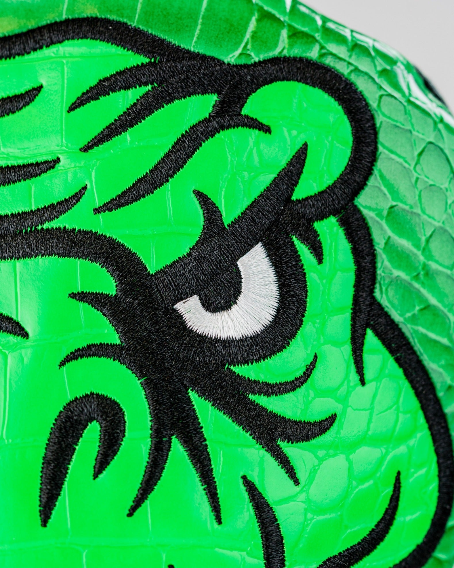 Bright green T-Rex driver cover featuring detailed black embroidery of a dinosaur's face, perfect for bold golfers.