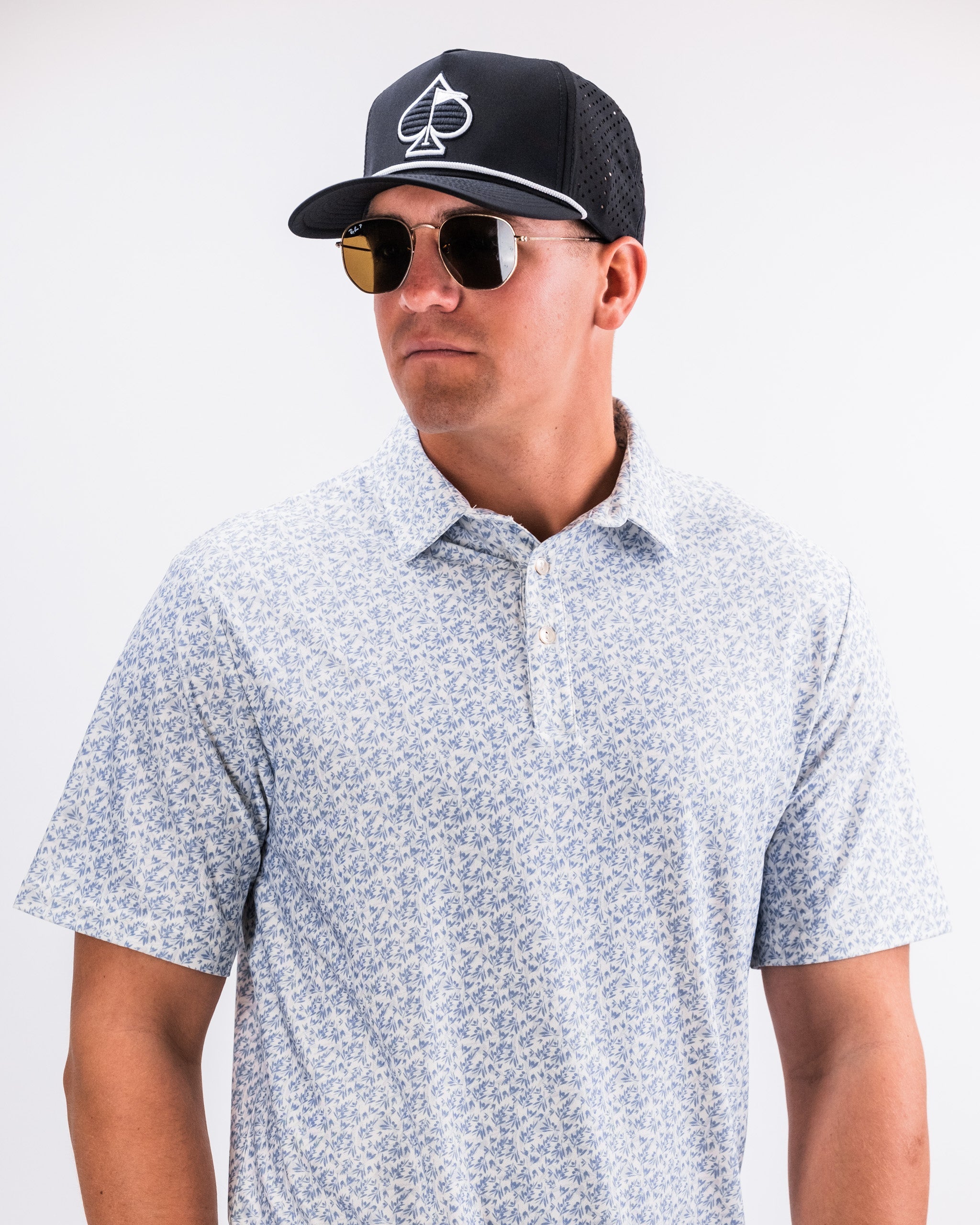 Olive green Player Preferred™ polo shirt displayed on a wooden table with a textured background.