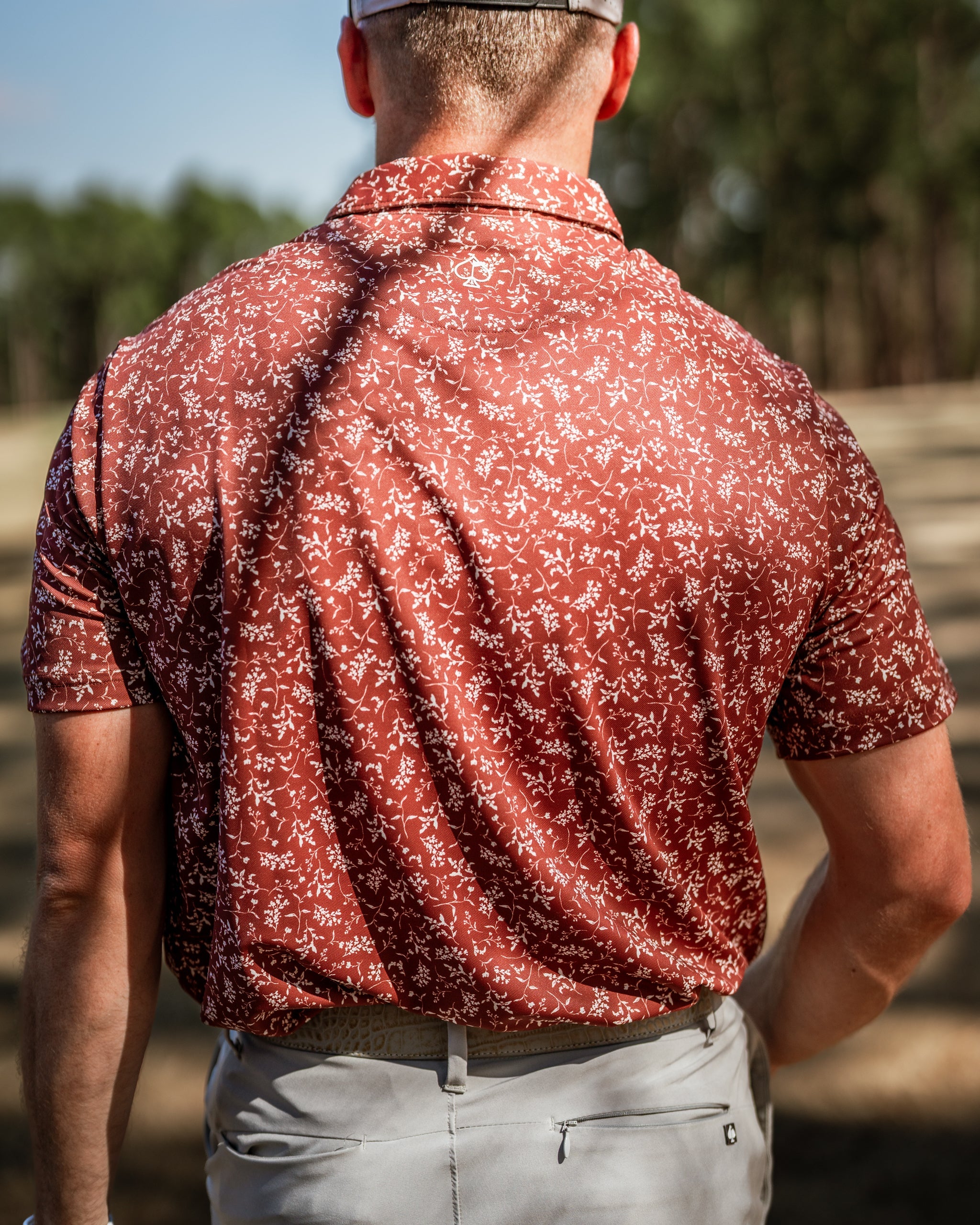 Men's short-sleeve golf shirt in autumn hues with a floral pattern, designed for stylish performance on the course.