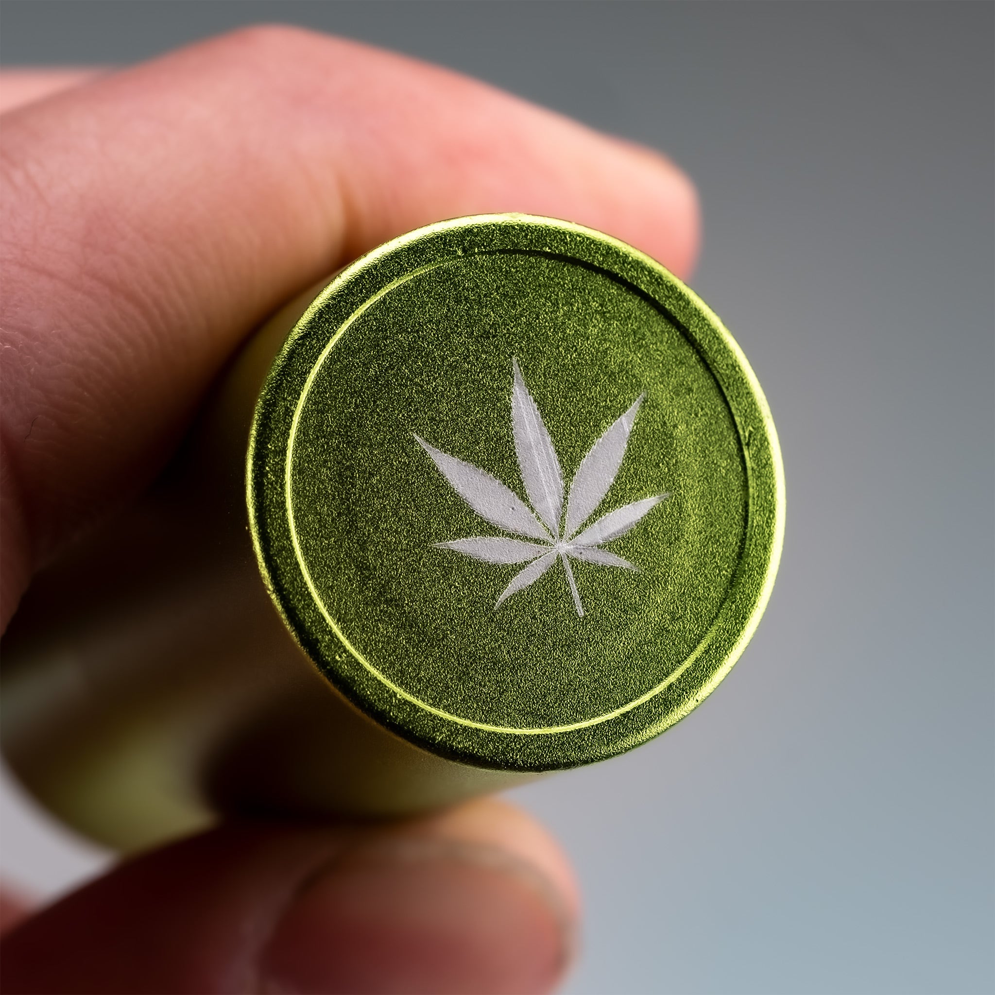 Pot Leaf Ball Stamp held in a closed hand, featuring a detailed leaf design perfect for crafts or baking.