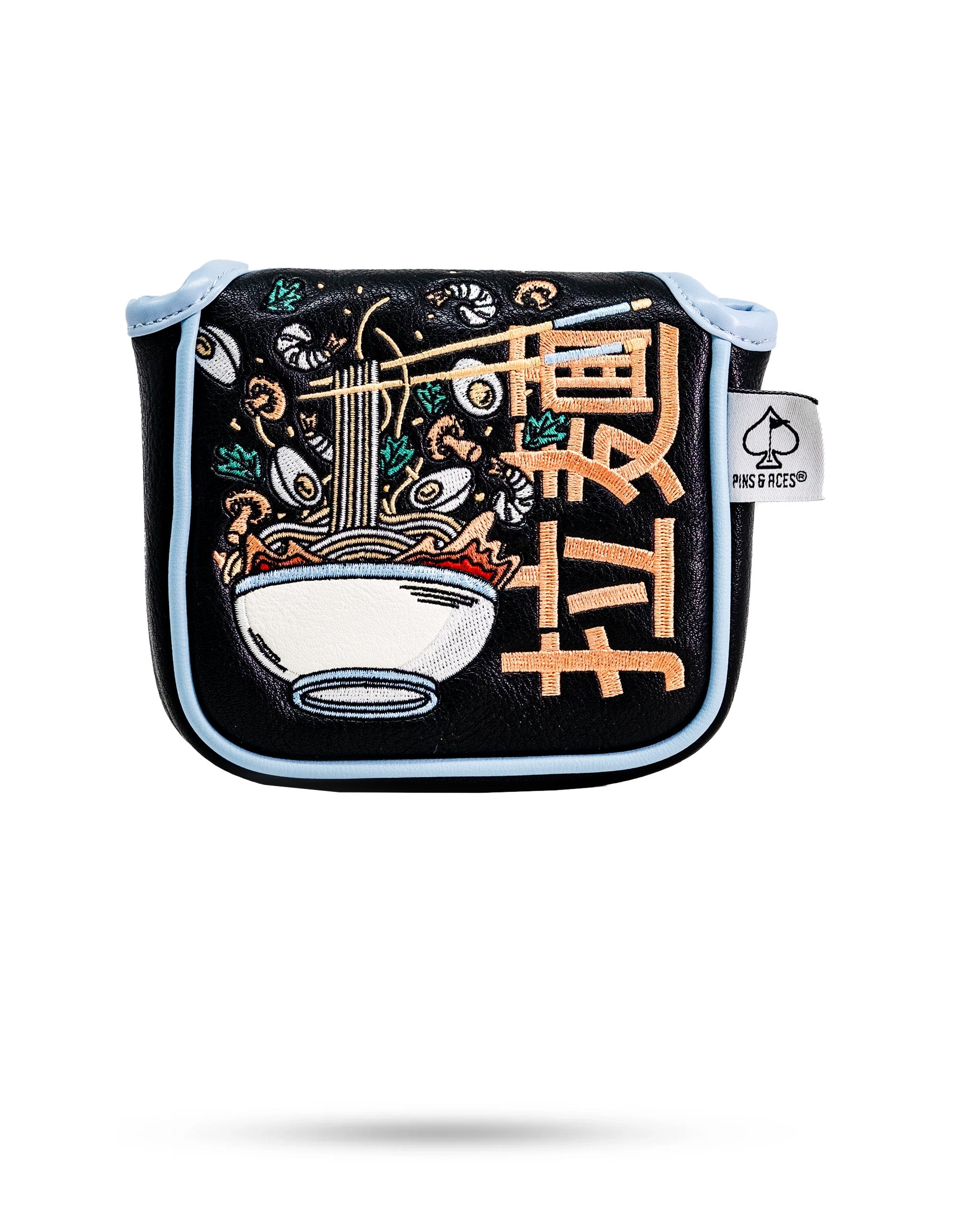 Embossed ramen bowl with noodles and chopsticks on a black Mallet Putter Cover with light blue trim and a Pins & Aces tag.
