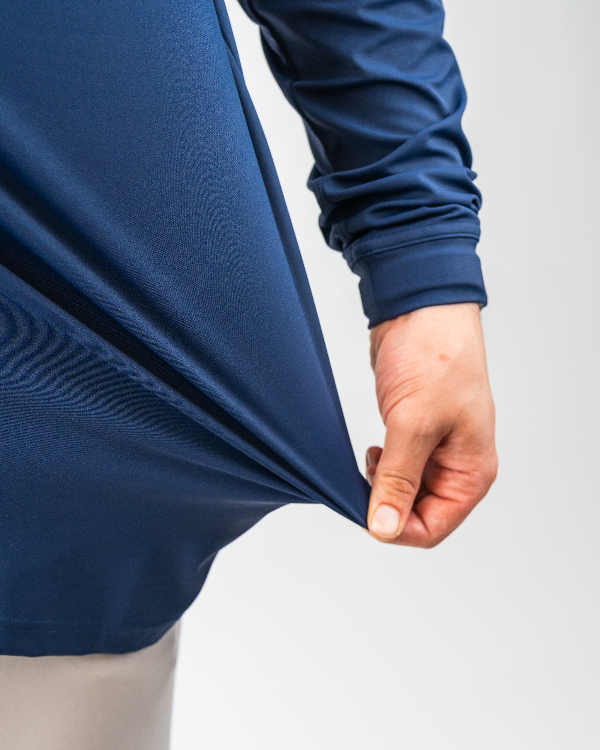 Close-up of a navy blue, water-resistant golf jacket with elastic cuffs, highlighting bold style for standout golf apparel.