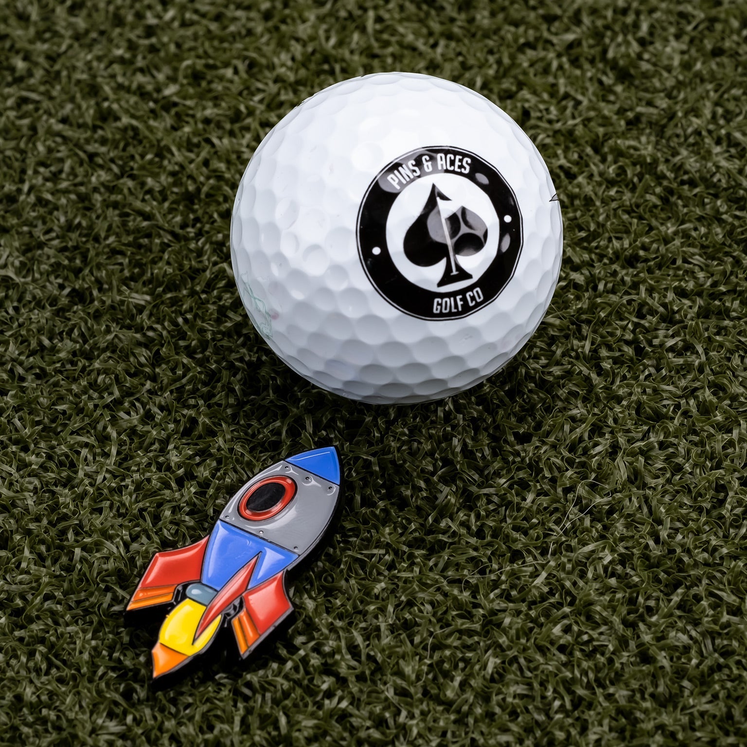 Rocket emoji ball marker featuring a colorful design, ideal for marking golf balls on the green.