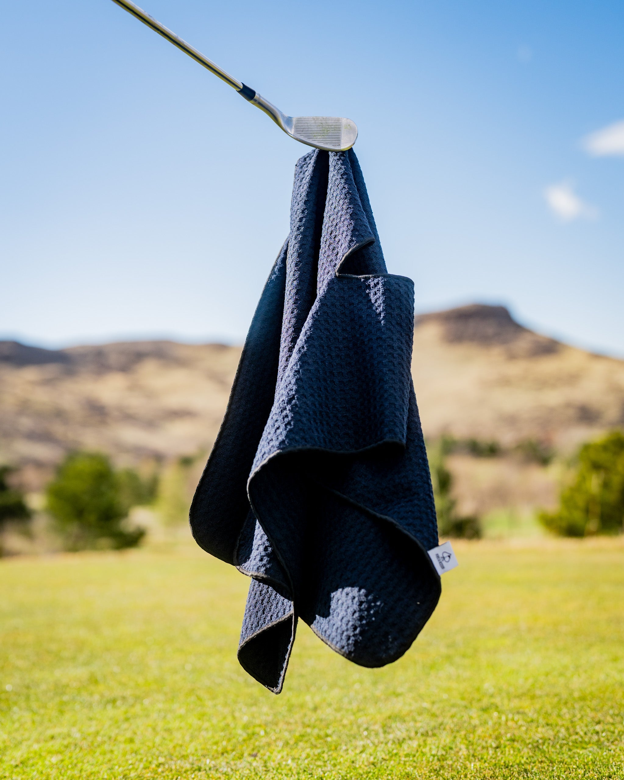 Black magnetic towel hanging on a hook, showcasing its sleek design and fabric texture.