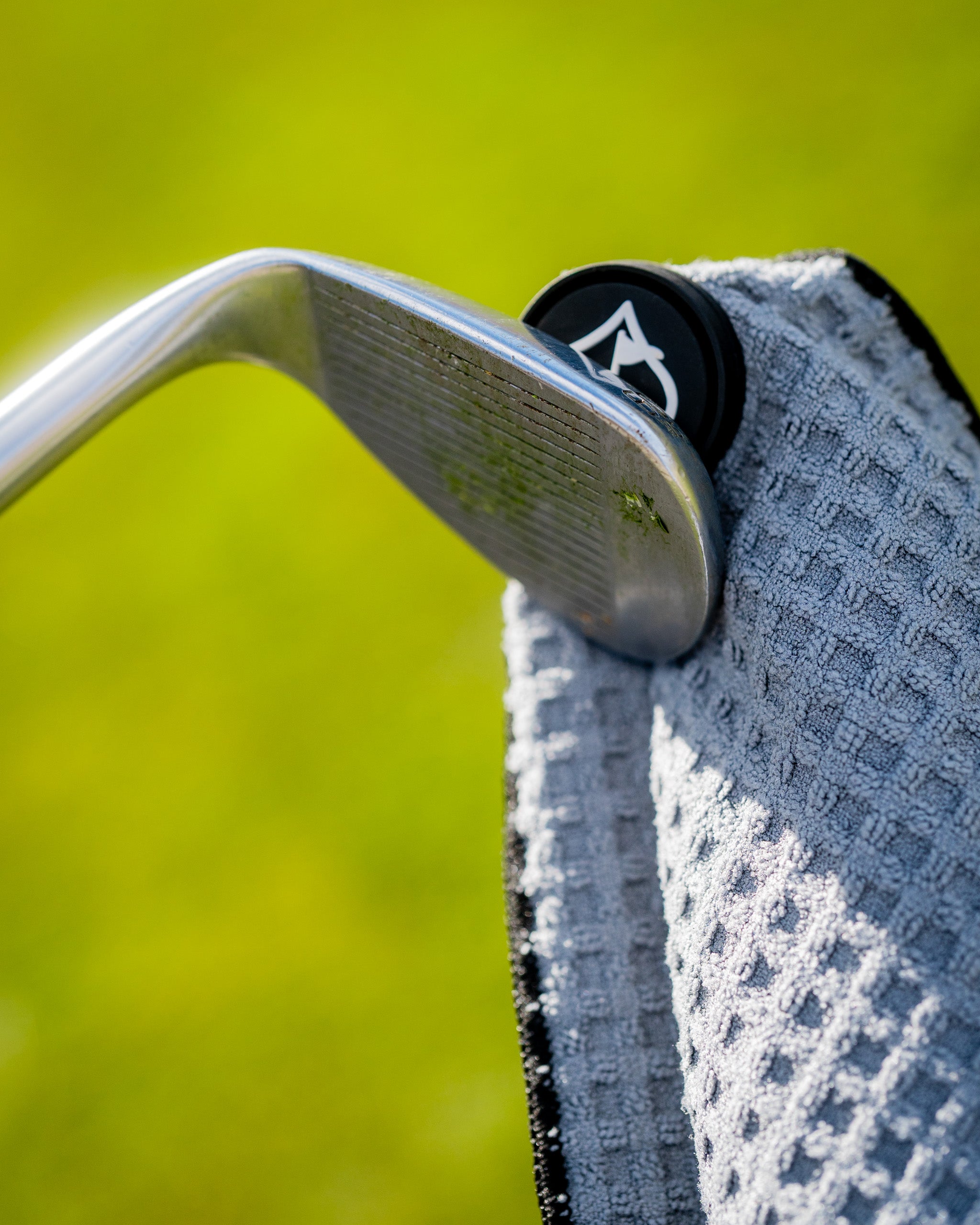 Gray magnetic towel hanging on a hook against a neutral background.