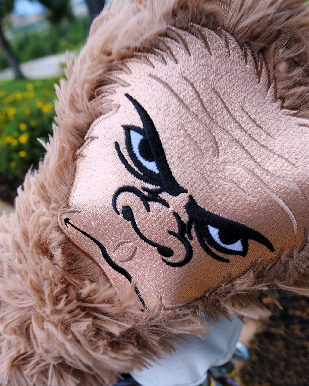 Sasquatch driver cover in a playful design, featuring a cartoon Bigfoot, placed on golf clubs.