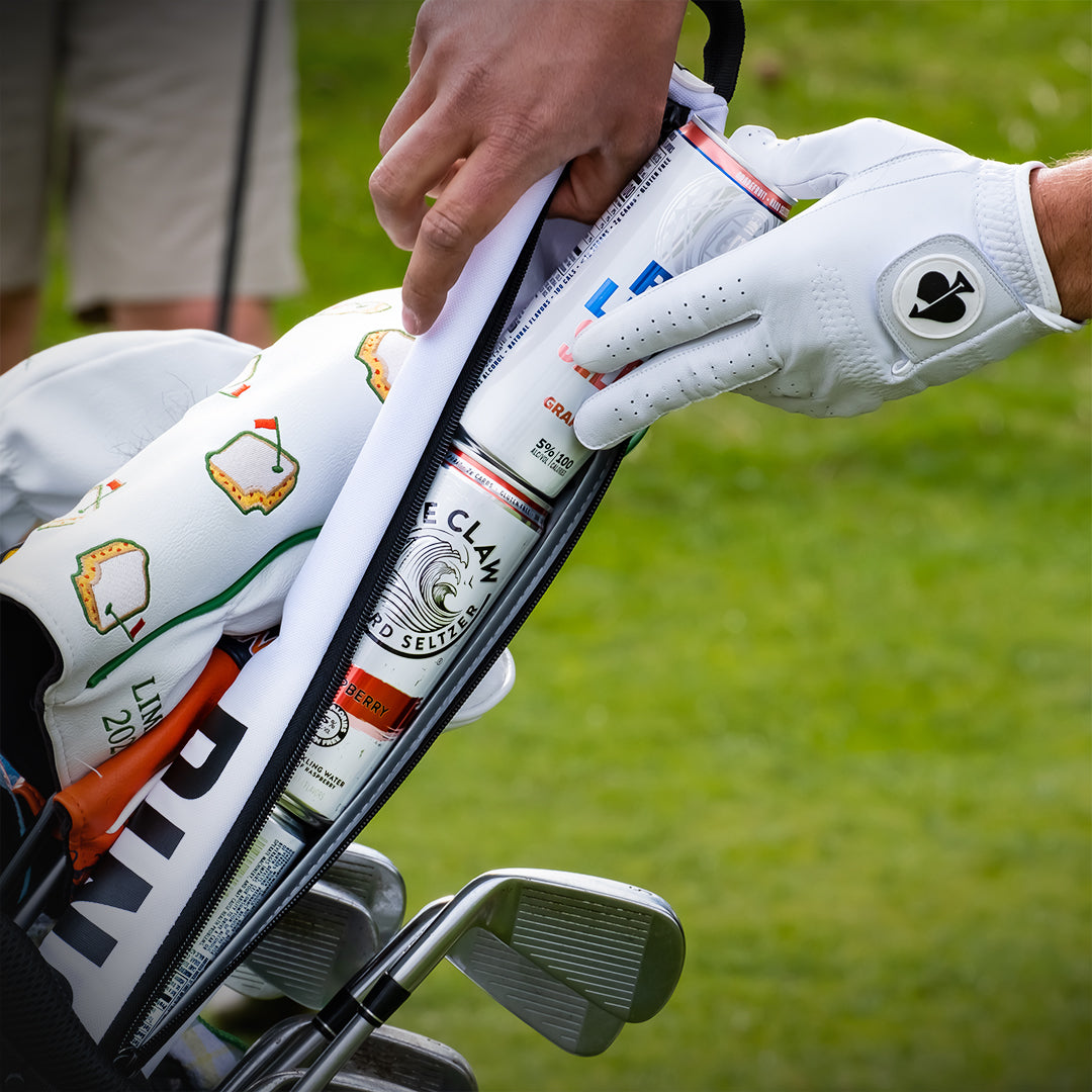 Seltzer Sleeve featuring a stylish design for holding cans, shown with a seltzer can placed inside a bag next to golf clubs.