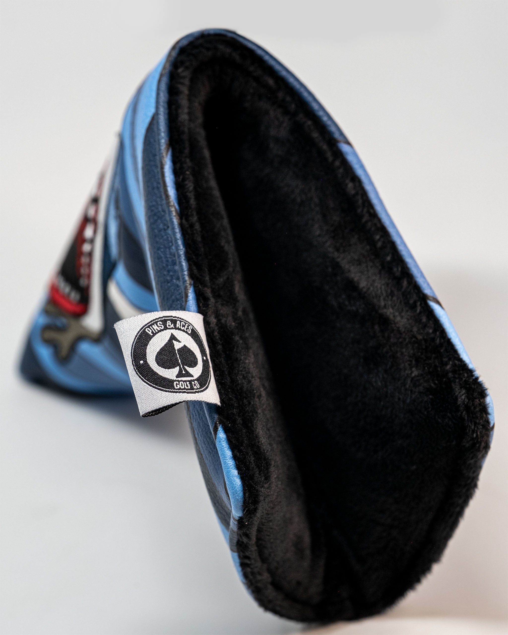 Shark Attack Blade Putter Cover featuring a vibrant shark design with bold colors on a sleek black background.