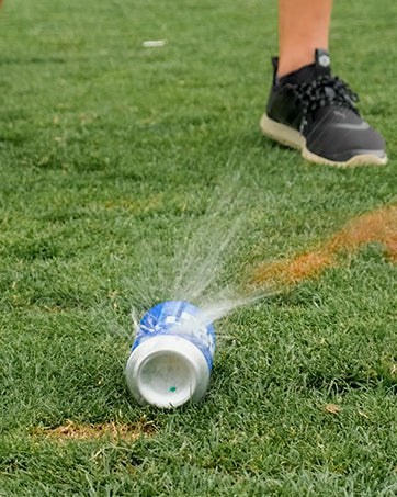 Three white Shottee golf tees arranged in an action shot on a green background.