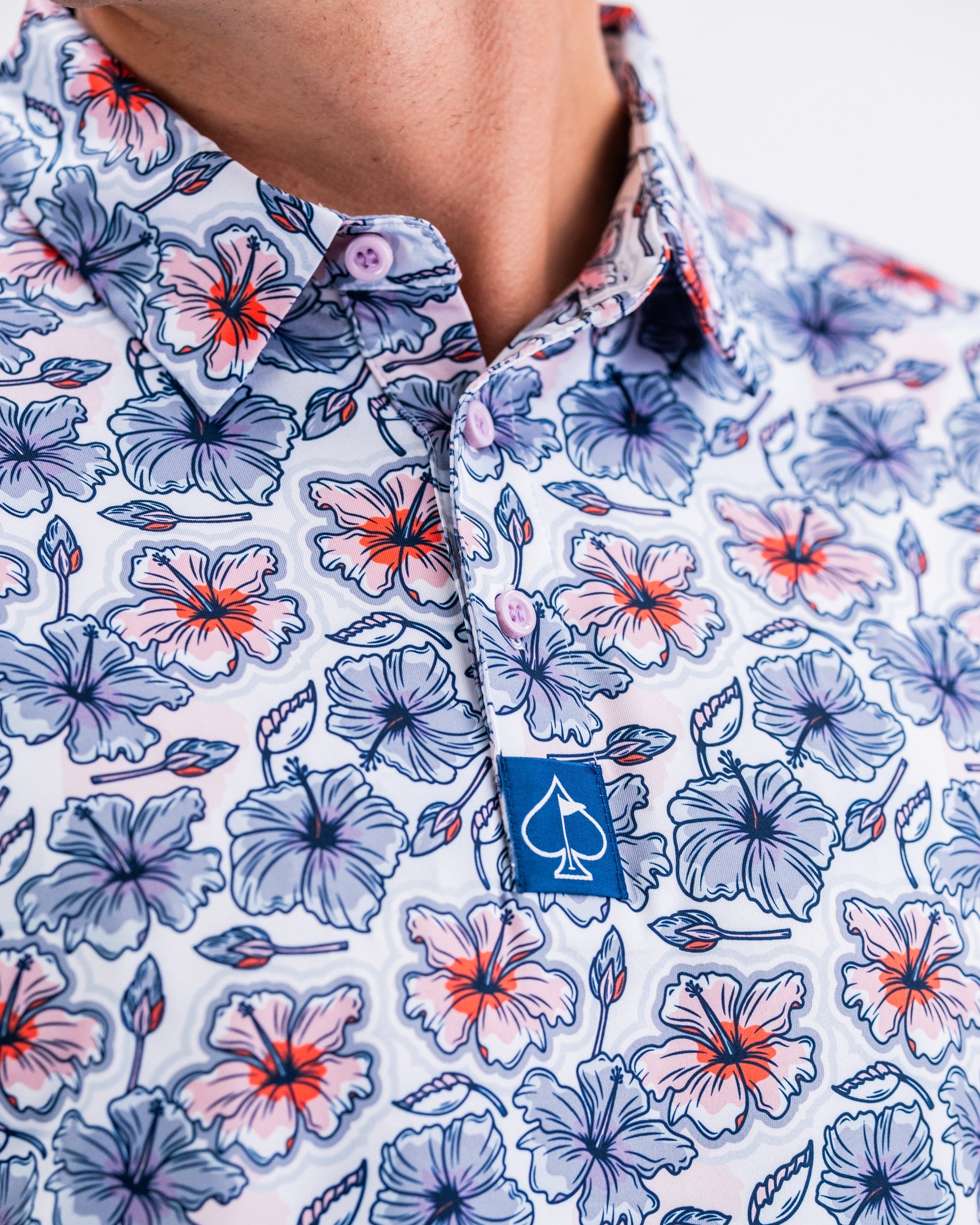 Hibiscus Harmony men's shirt featuring a vibrant floral pattern in bold colors on a light background.