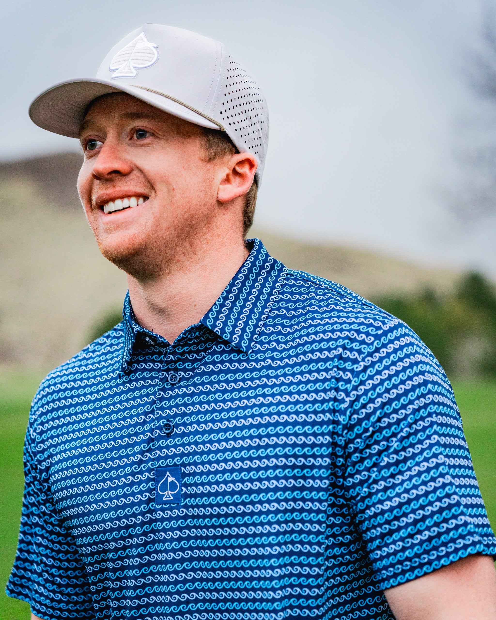 Scenic landscape of rolling hills under a bright blue sky with fluffy white clouds, showcasing vibrant green grass and a serene atmosphere.