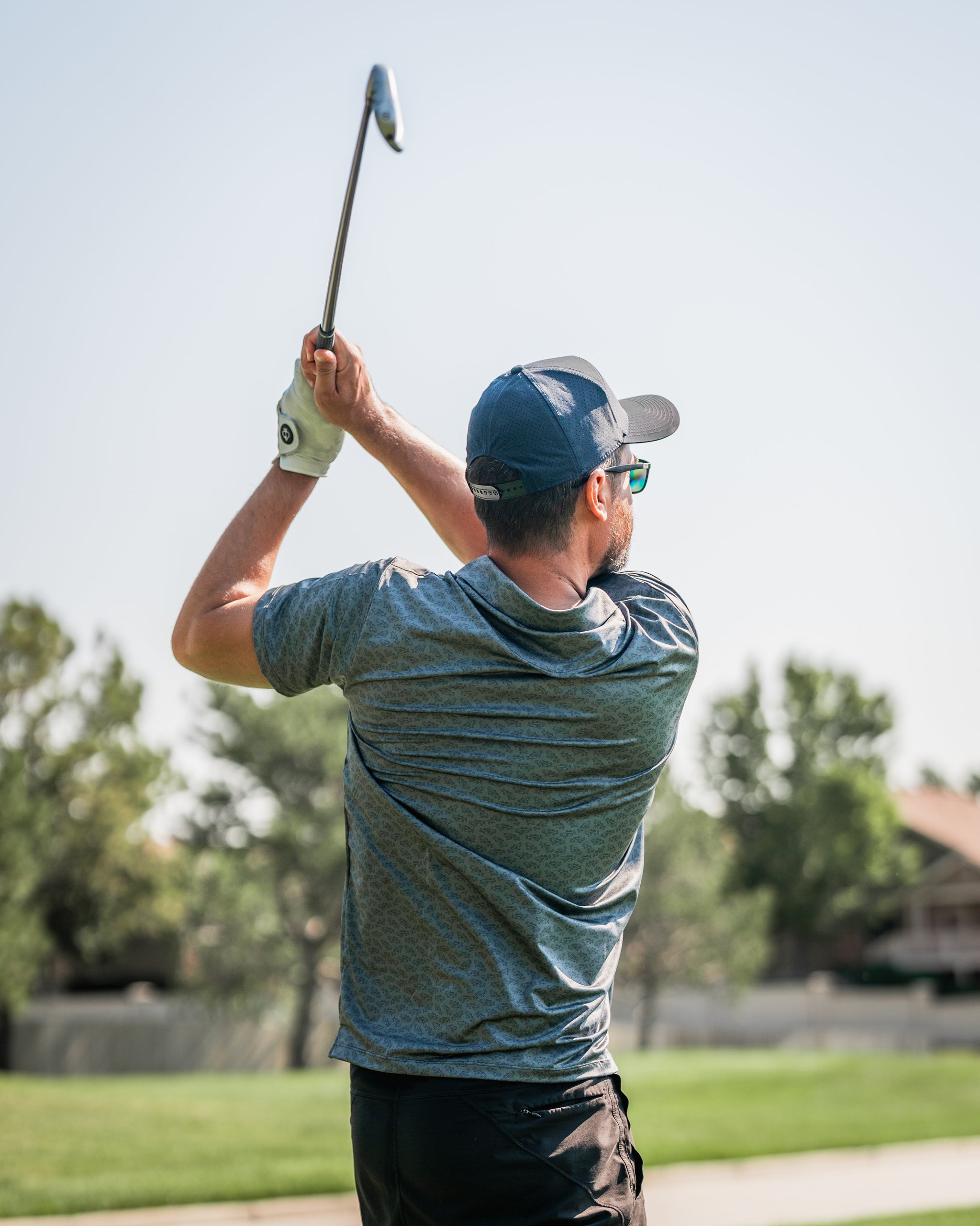 Golfer in a blue shirt and cap swings a club on a sunny course, showcasing the Large Mouth golf headcover.