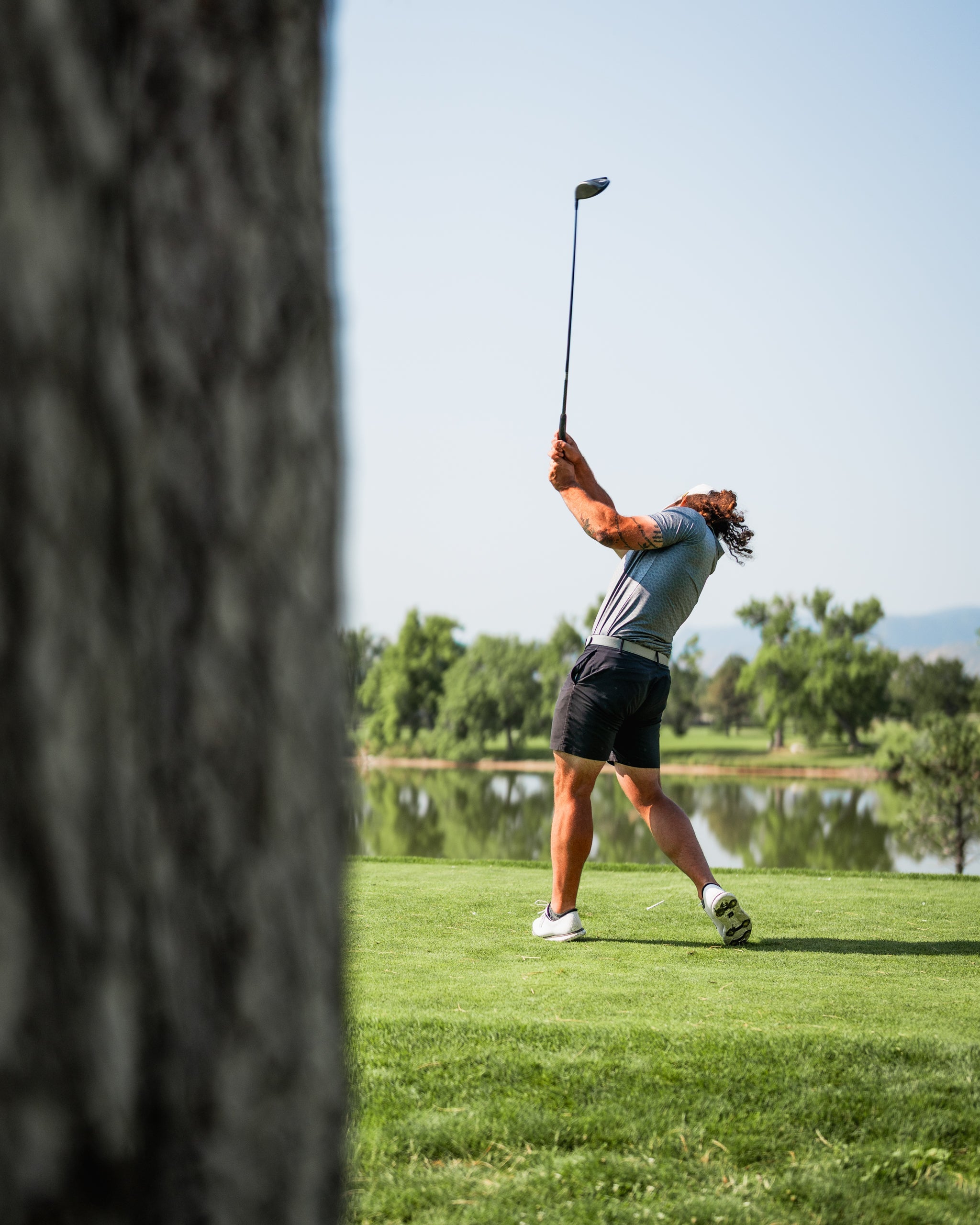 Golfer swinging a club on a sunny course, showcasing the Large Mouth headcover in the background.