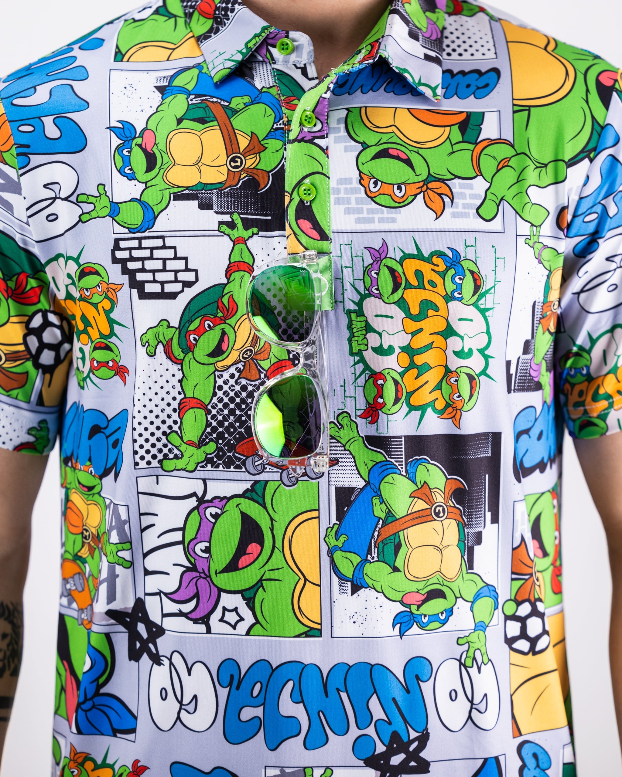 TMNT comic strip graphic featuring Teenage Mutant Ninja Turtles in action scenes on a polo shirt.