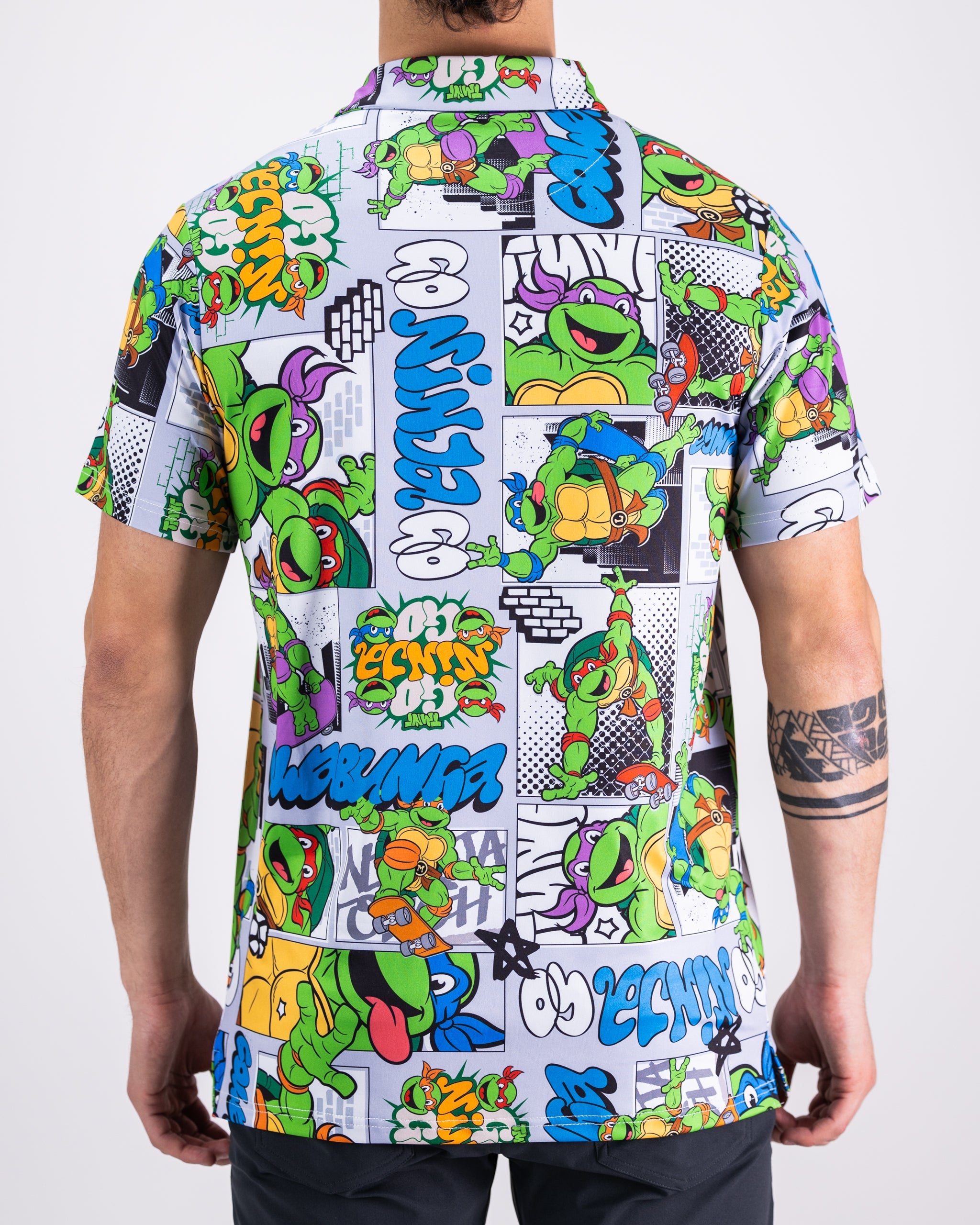 TMNT comic strip graphic polo shirt featuring colorful Teenage Mutant Ninja Turtles artwork.