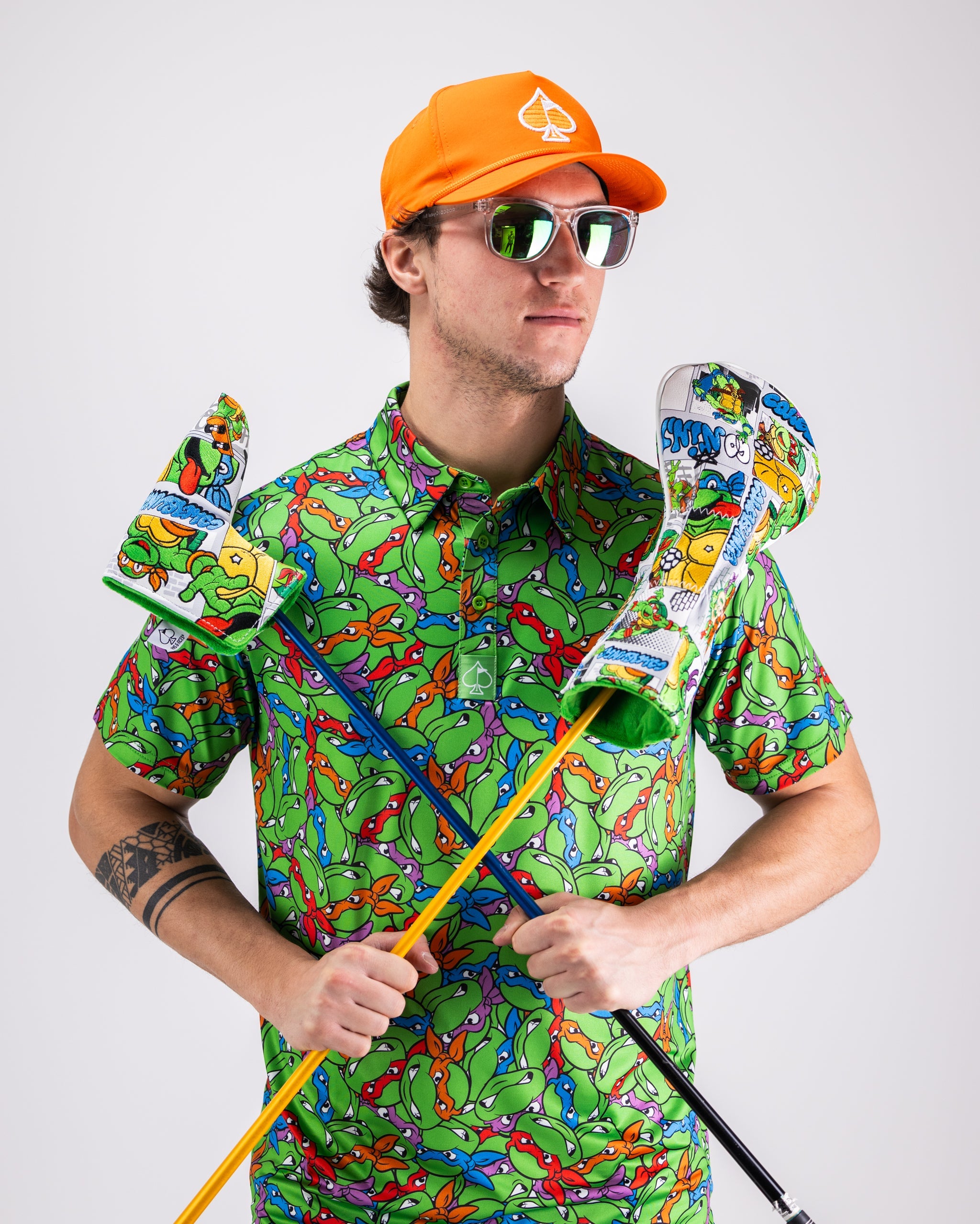 TMNT Mean Green polo shirt featuring colorful turtle head graphics on a vibrant green background.