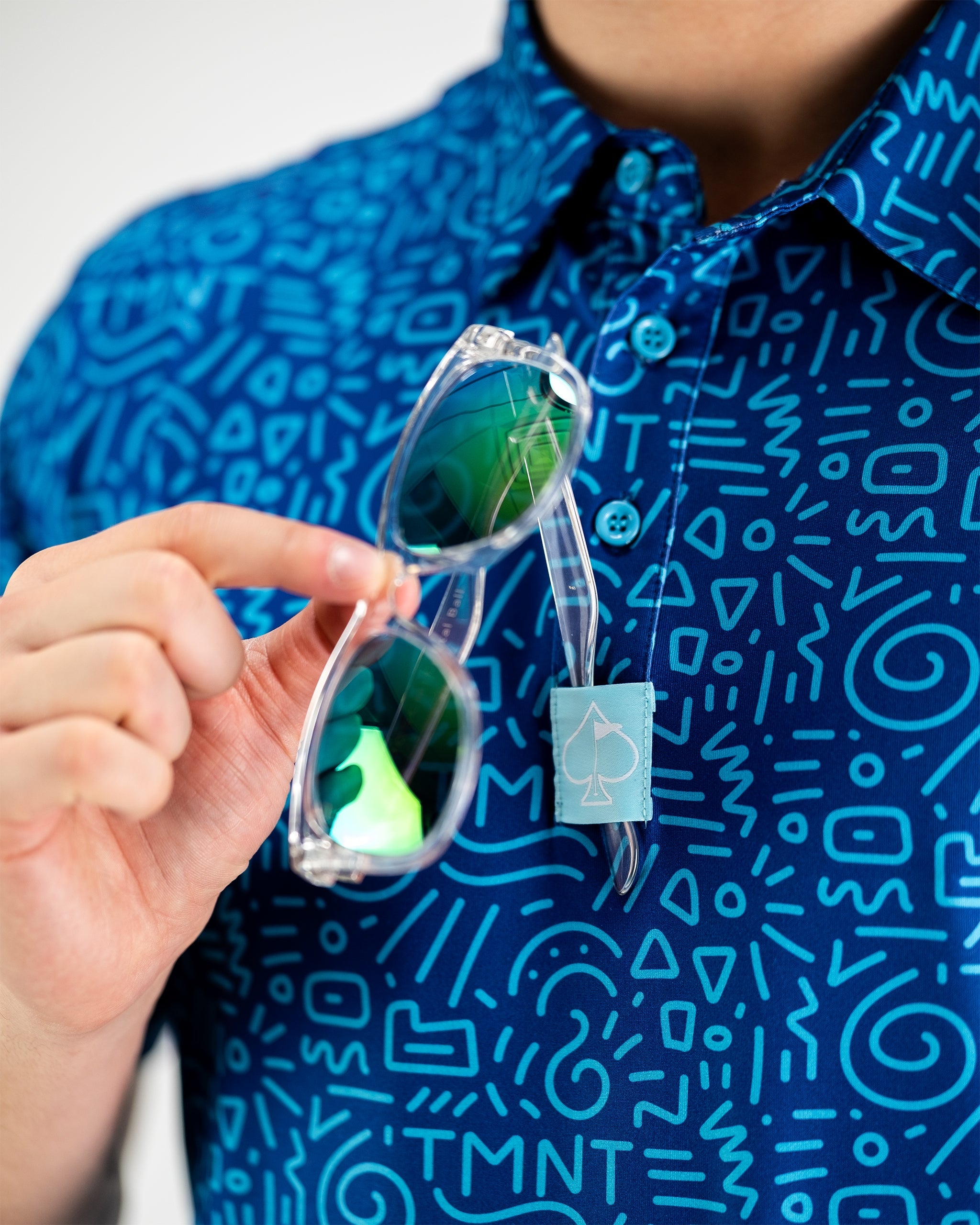 TMNT Doodle design featuring colorful illustrations of Teenage Mutant Ninja Turtles on a polo shirt.