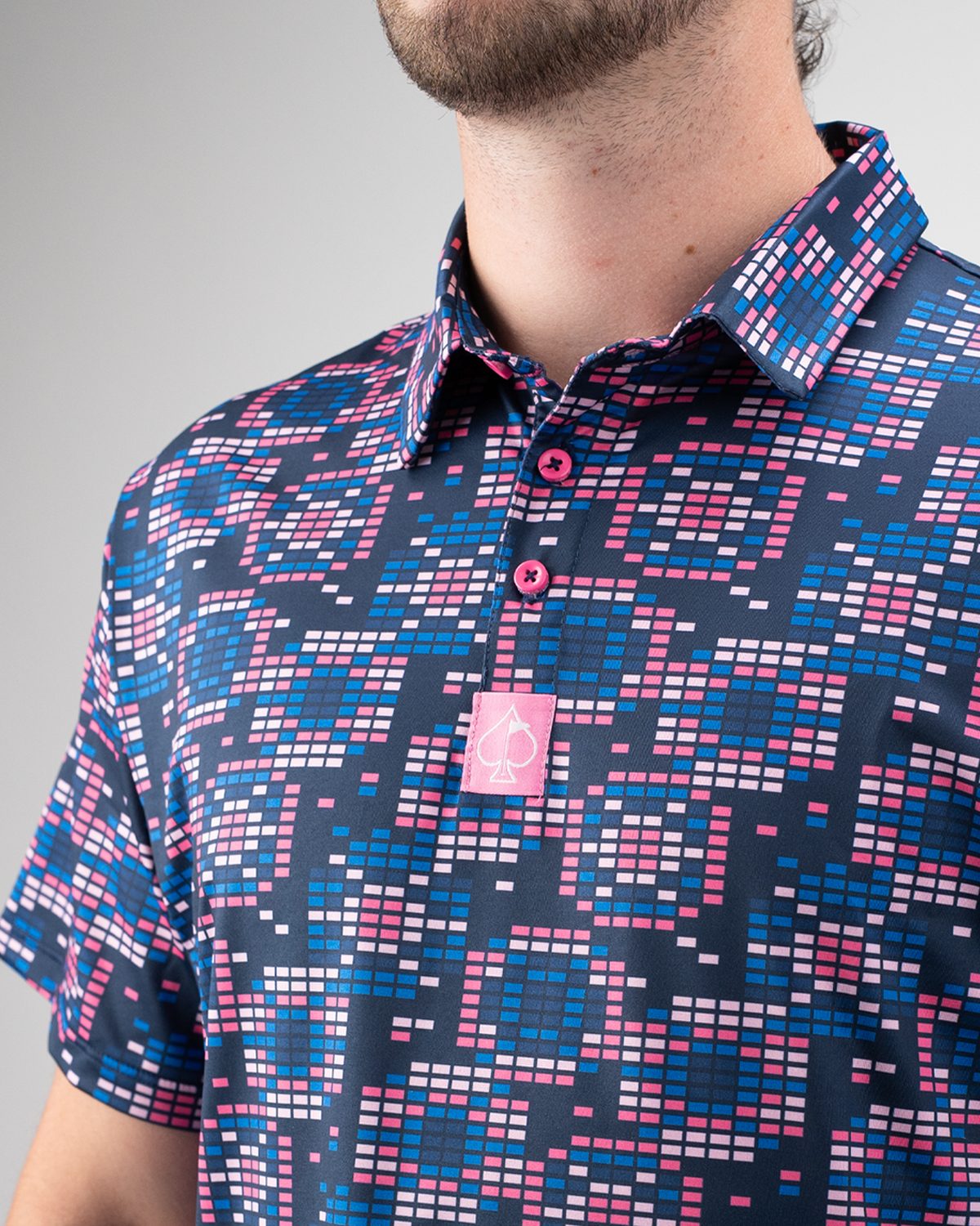 Men's Tetrafloral Dark golf shirt featuring a vibrant geometric pattern in pink, blue, and navy with a logo on the chest.