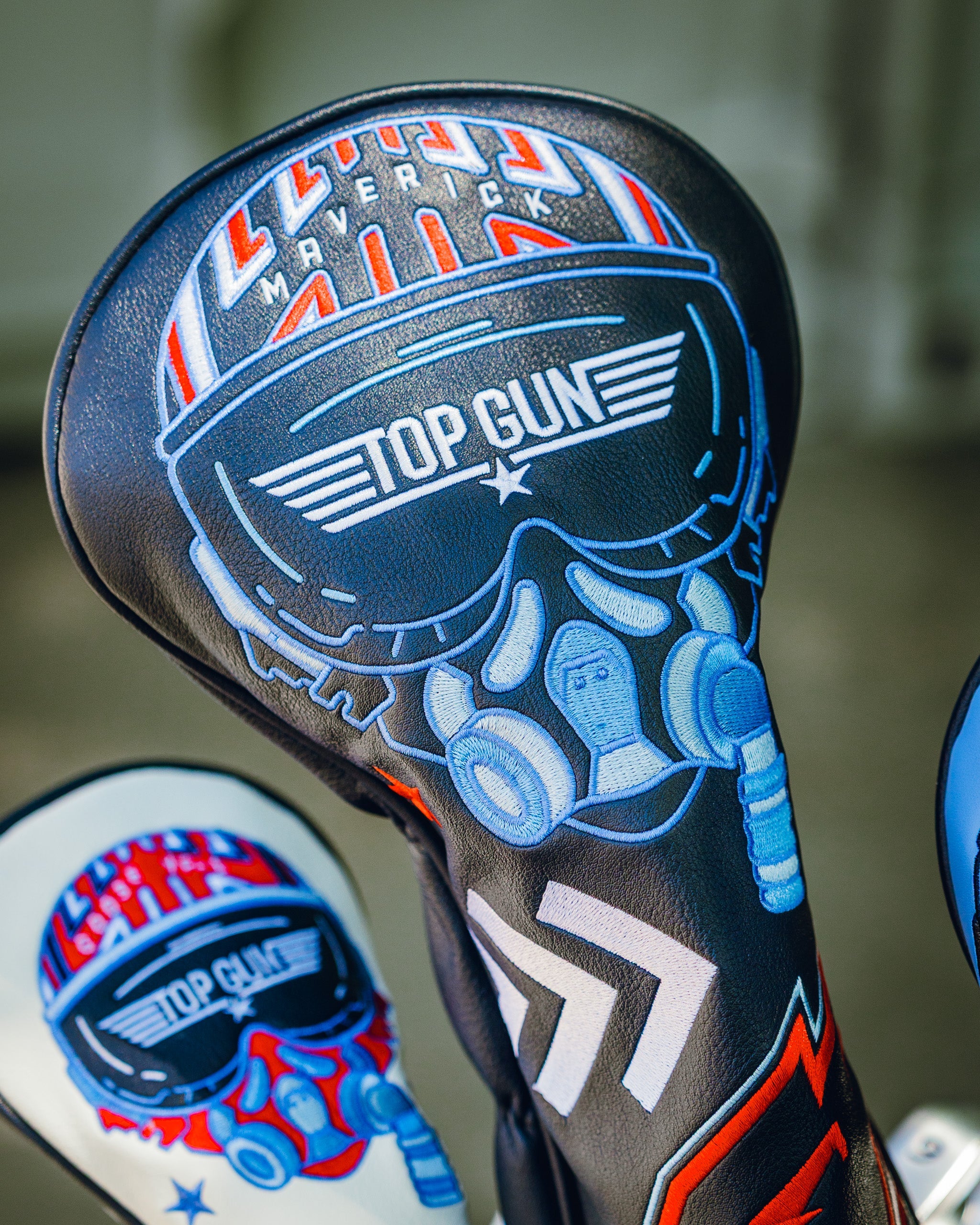 Top Gun Maverick golf driver headcover with a skull wearing sunglasses and headphones, featuring bold graphics and vibrant colors.