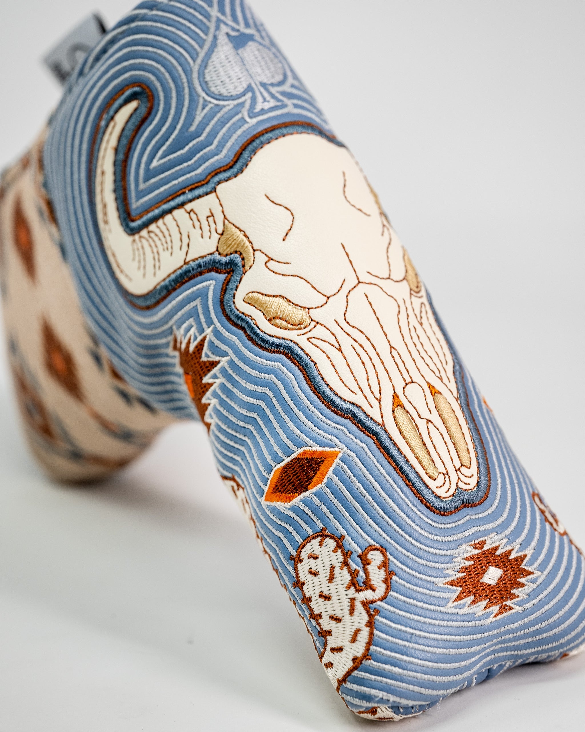 Embroidered Western Aesthetic Blade Putter Cover featuring a detailed skull, cacti, and desert motifs in blue, beige, and orange tones.