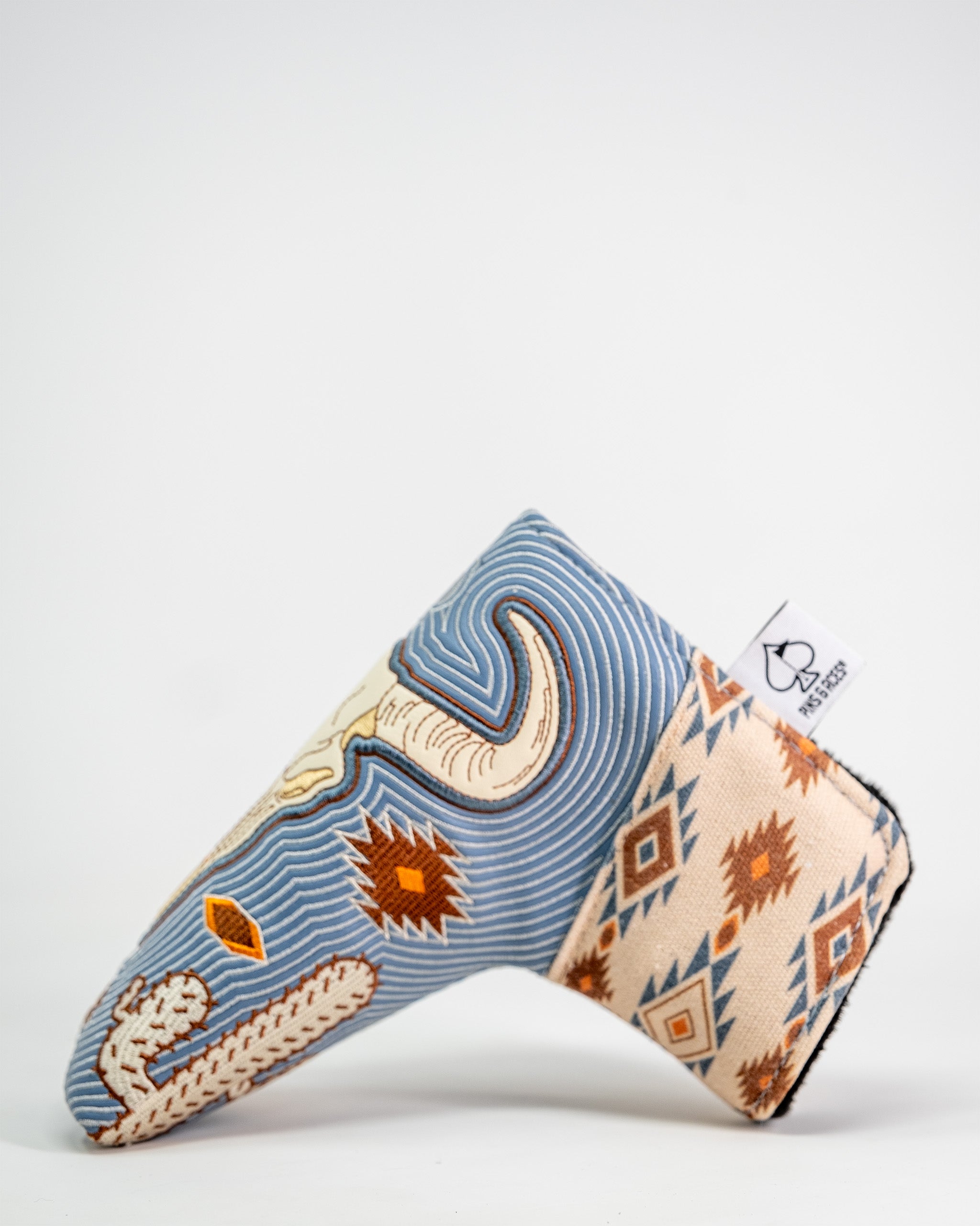 Western aesthetic blade putter cover with a southwestern-inspired embroidered design in blue, beige, and brown tones.